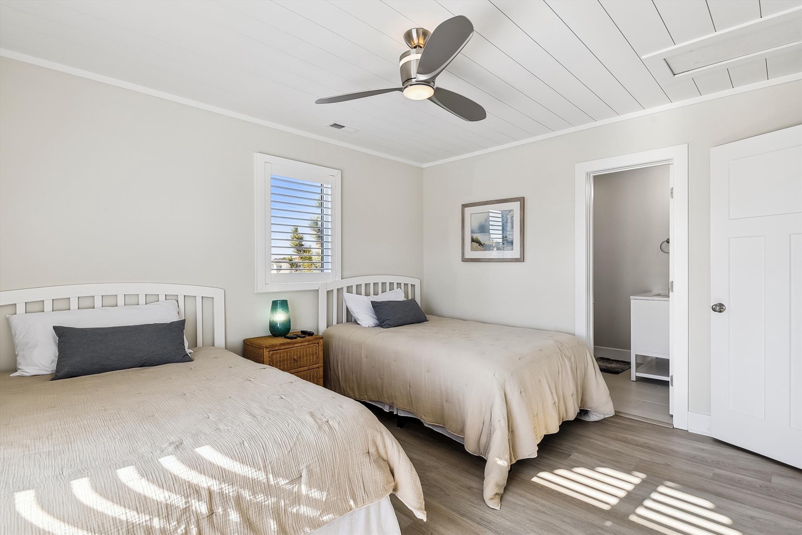 Drift off to sleep in this peaceful bedroom, where soft linens, warm wood tones, and natural light create your serene coastal retreat.