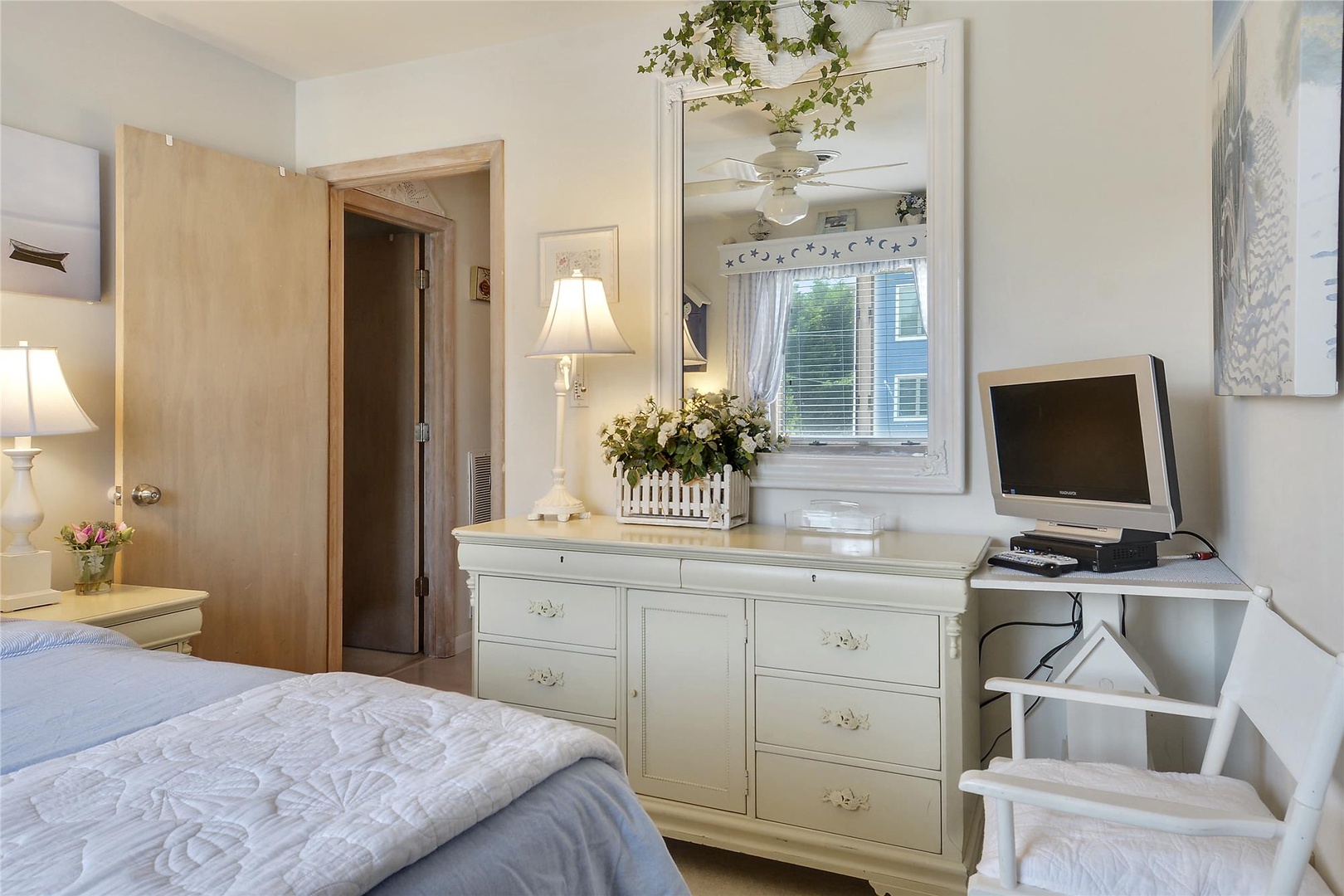 Step into your cozy retreat with charming cottage-style furniture, a vintage TV for your entertainment, and soft natural light streaming through the window.