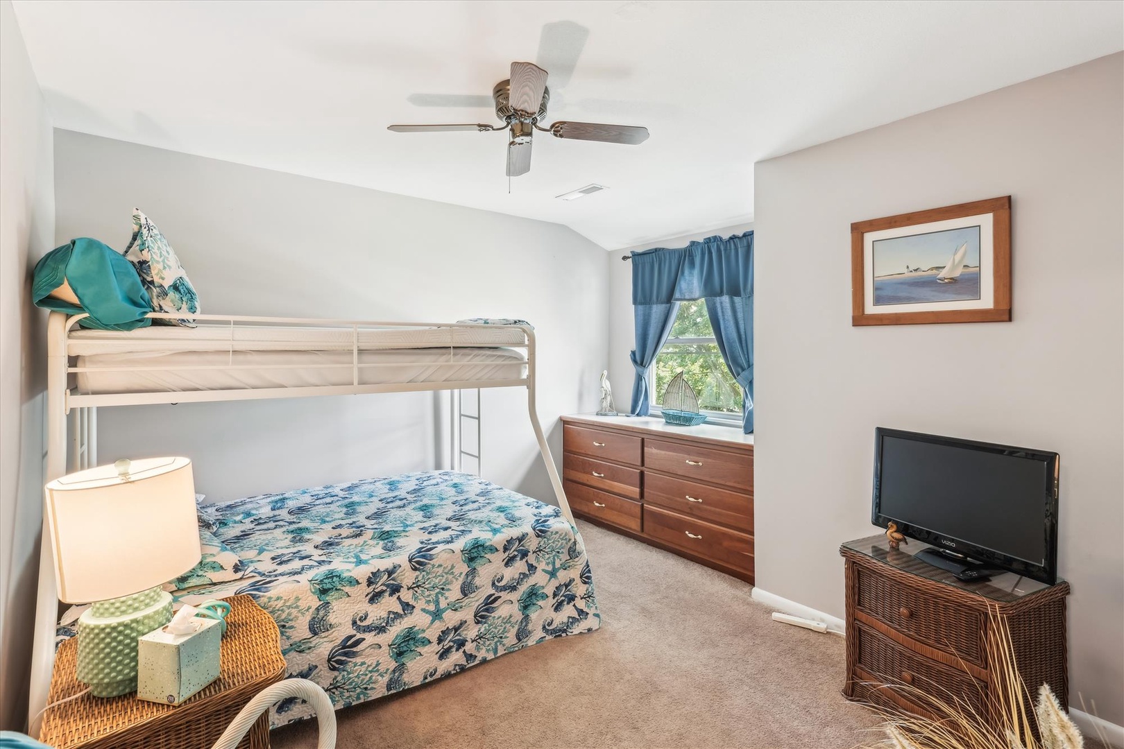 Your kids will love this cheerful bunk bed room with its ocean-themed bedding, ceiling fan for comfort, and TV for movie nights.