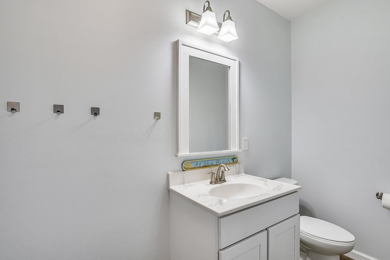 Crisp and clean, your bathroom features a bright vanity with modern fixtures and thoughtful touches like wall hooks for your towels and robes.