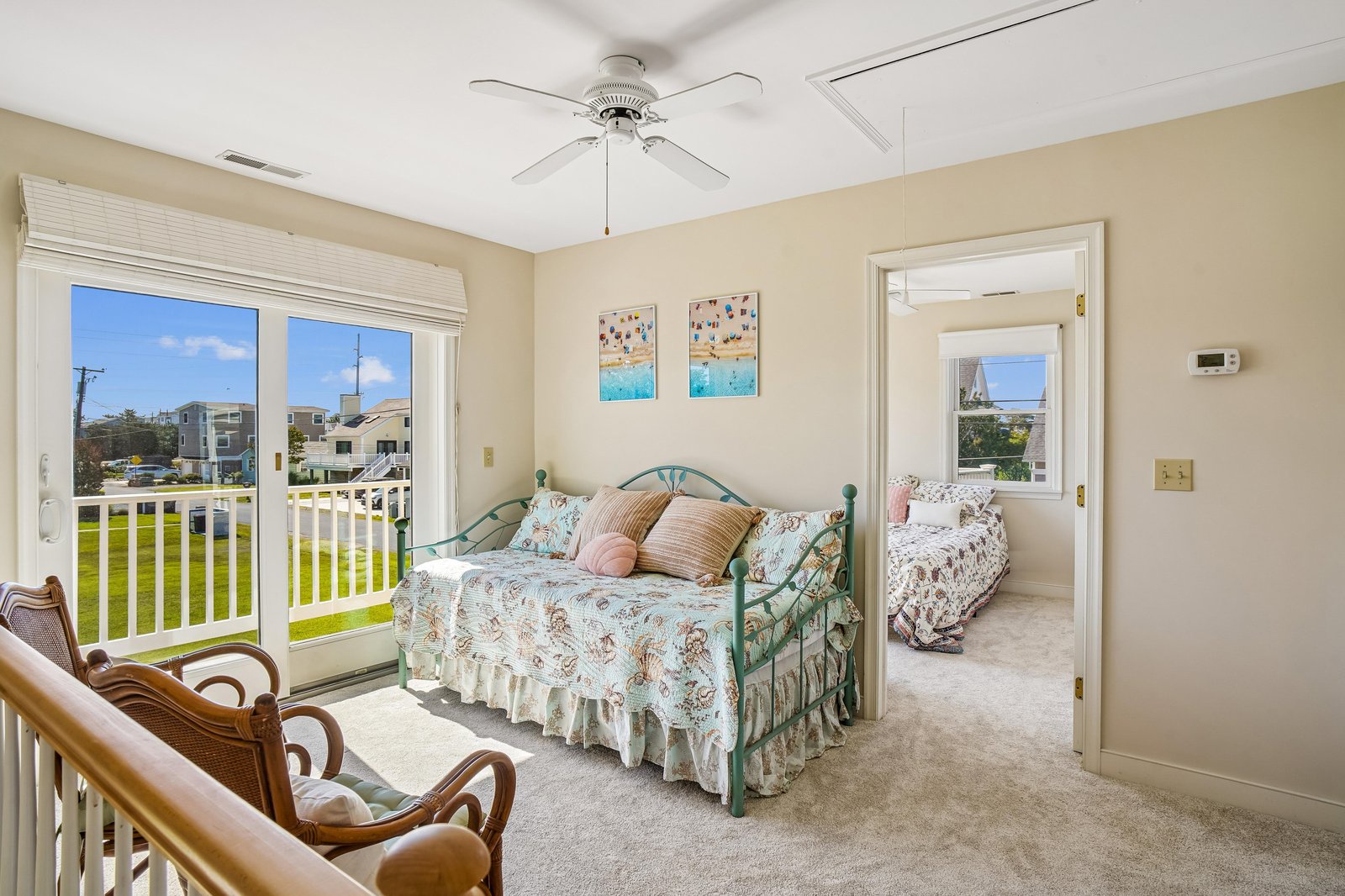 Your sunny coastal retreat awaits with soft linens, gentle breezes from the ceiling fan, and charming beach-themed touches. Wake up to bright morning light and peaceful neighborhood views.