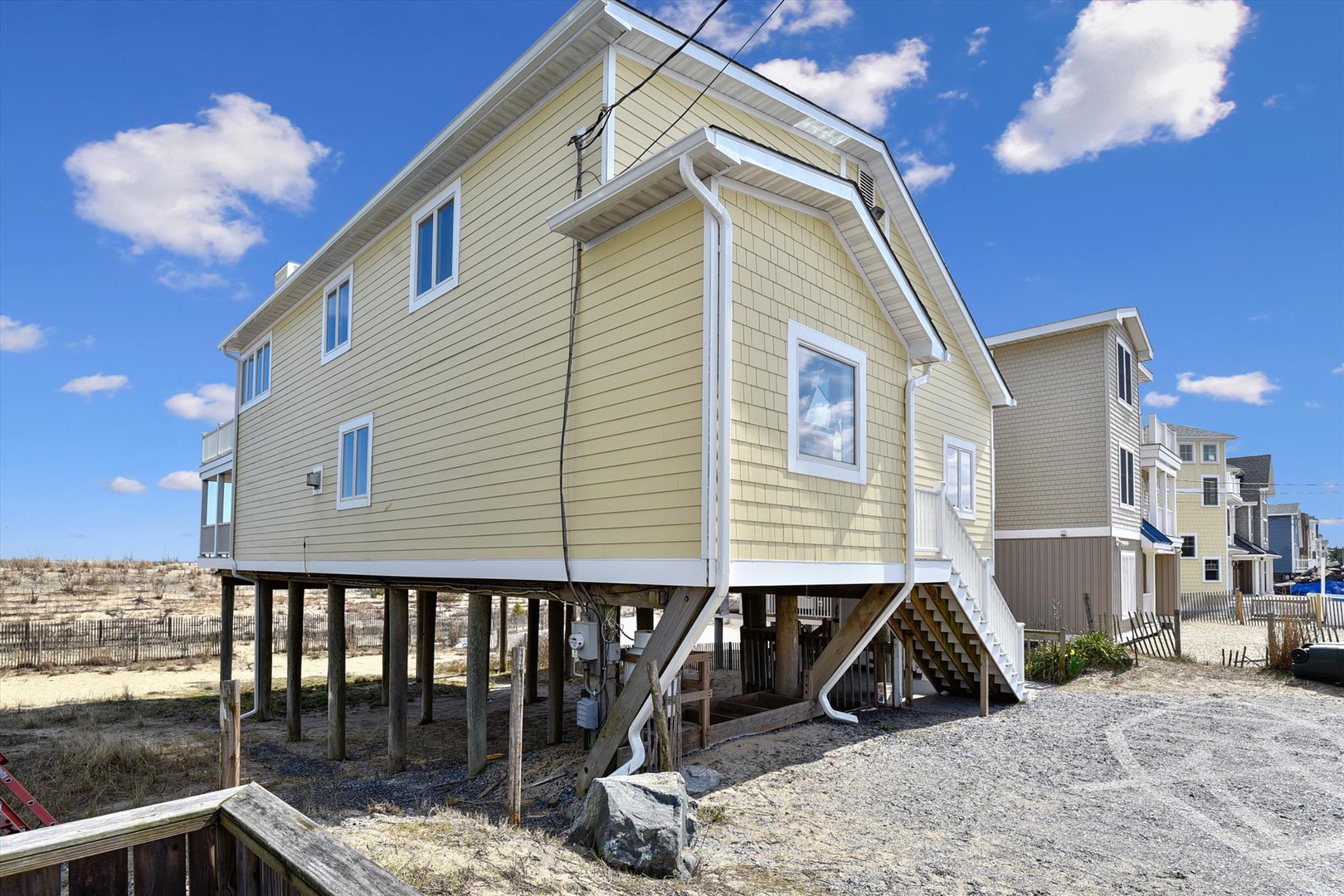 Coastal vacation rental elevated on stilts, located in a beachfront neighborhood with convenient beach access just steps away from the sandy shore.
