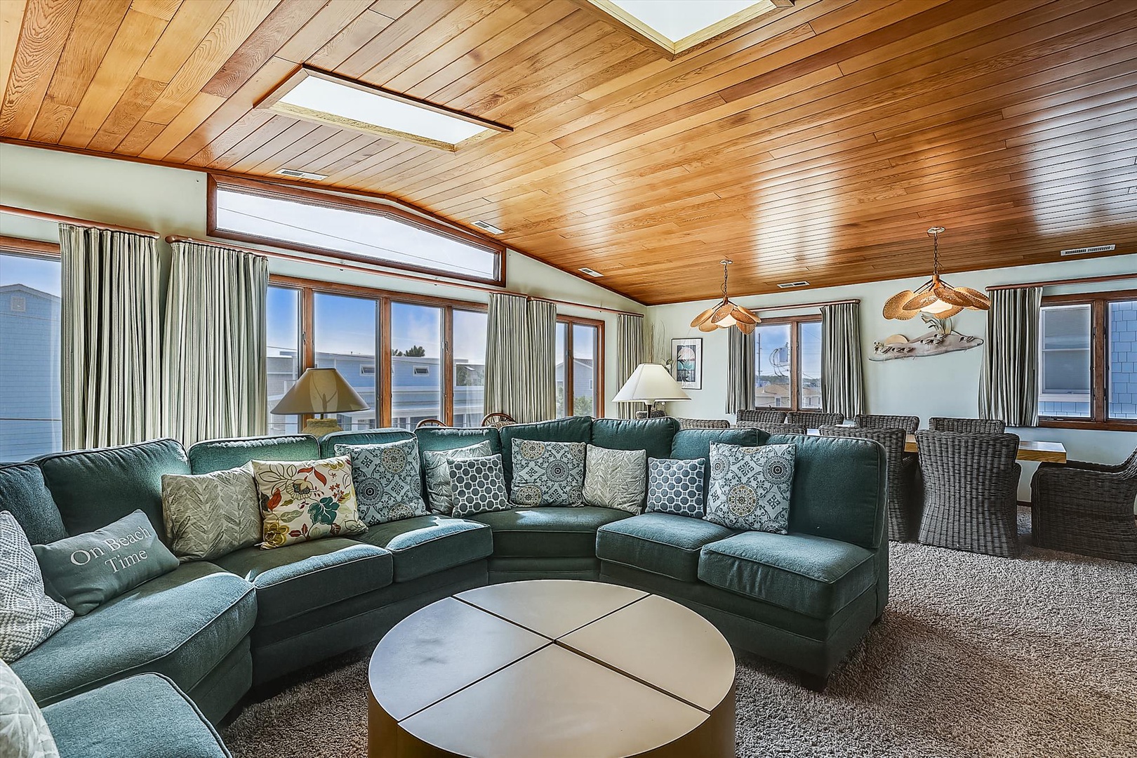 Sink into plush seating beneath warm wood-paneled ceilings and skylights that bathe your gathering space in natural light, with ocean views framing every conversation.