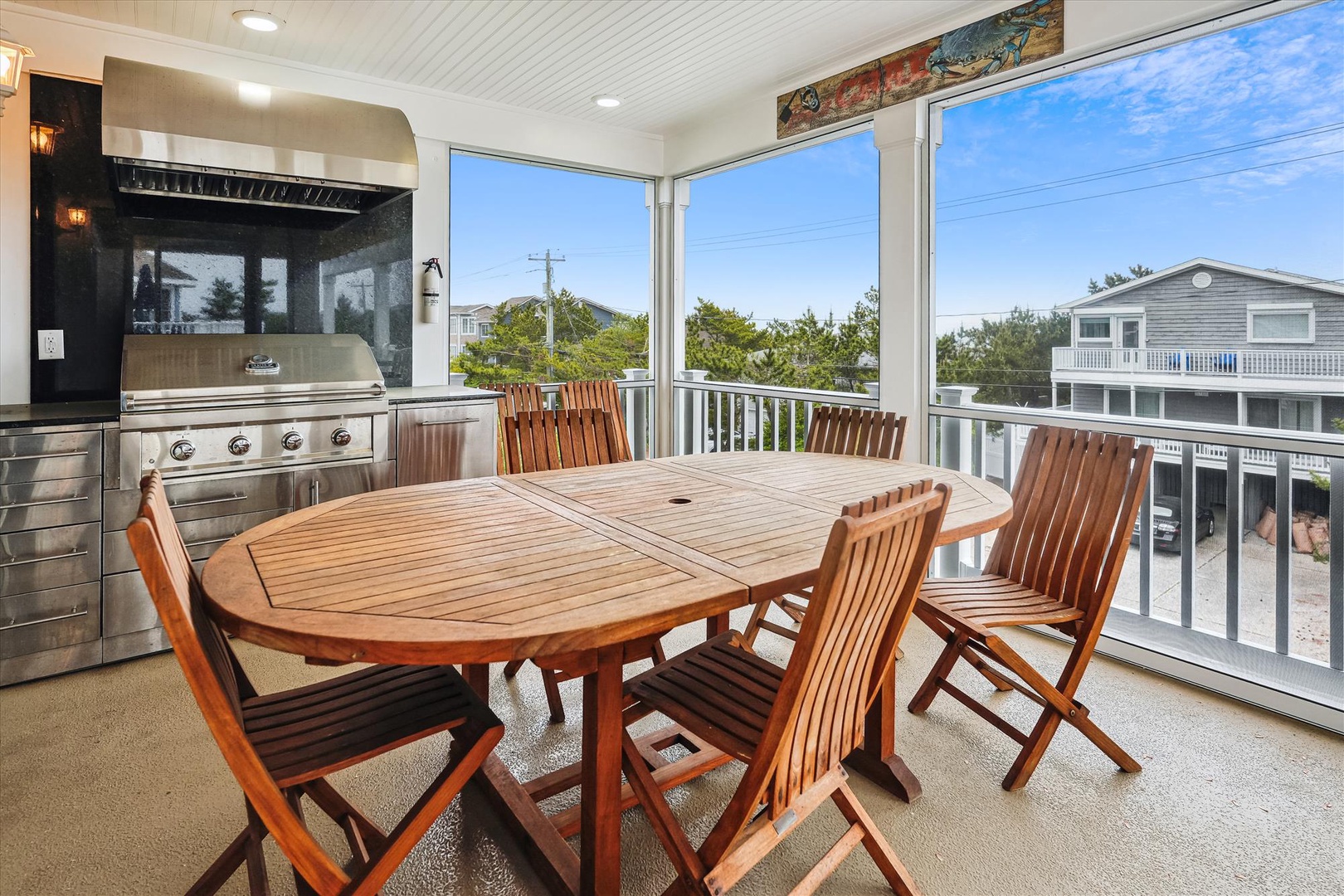 Gather around this spacious outdoor dining area, perfect for grilling and enjoying meals while taking in the neighborhood views through the large screened windows.
