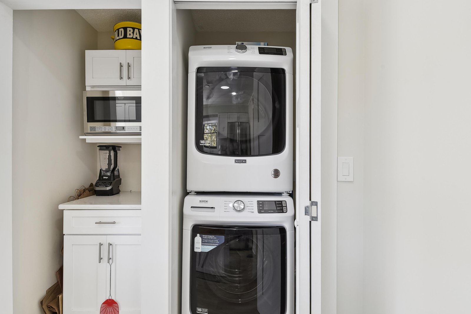 Your in-unit laundry closet features full-size, stacked appliances, with convenient prep space and a microwave nearby for everyday ease.