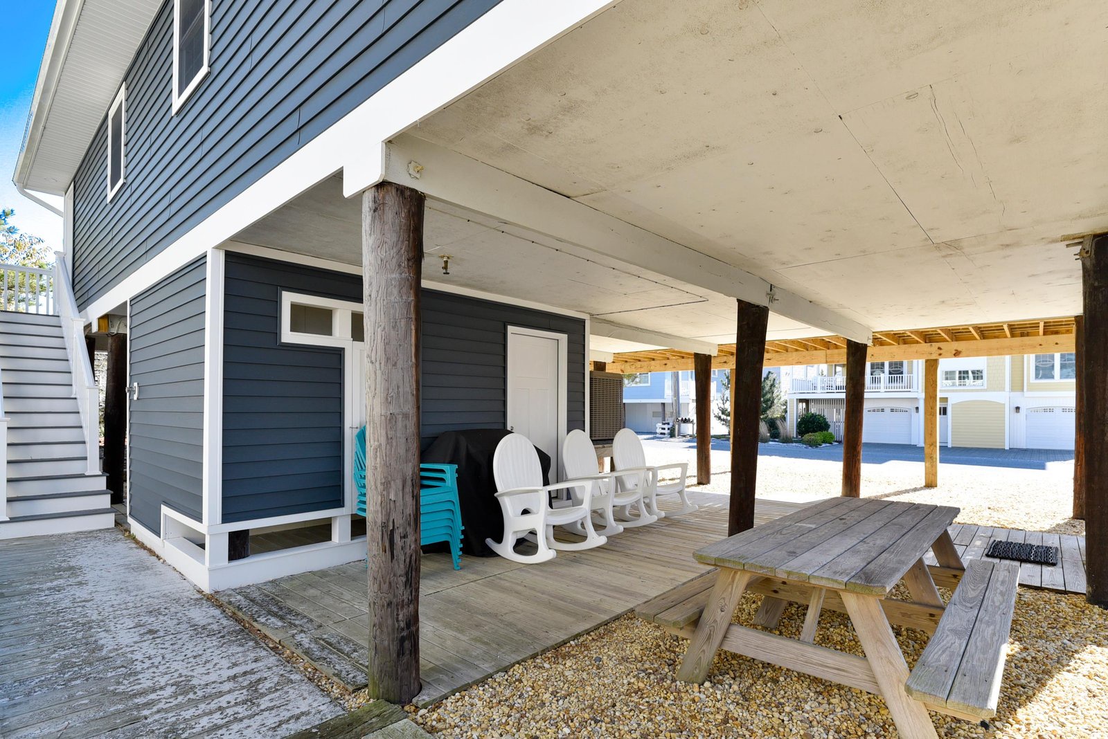 A covered outdoor space with a picnic table, beach chairs, and storage where you can relax in the shade after a day of coastal adventures.