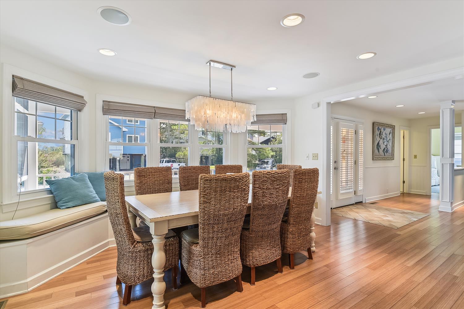 Gather around this inviting dining table where your family and friends can share meals and make memories together in this bright, airy space with warm wood floors and coastal charm.
