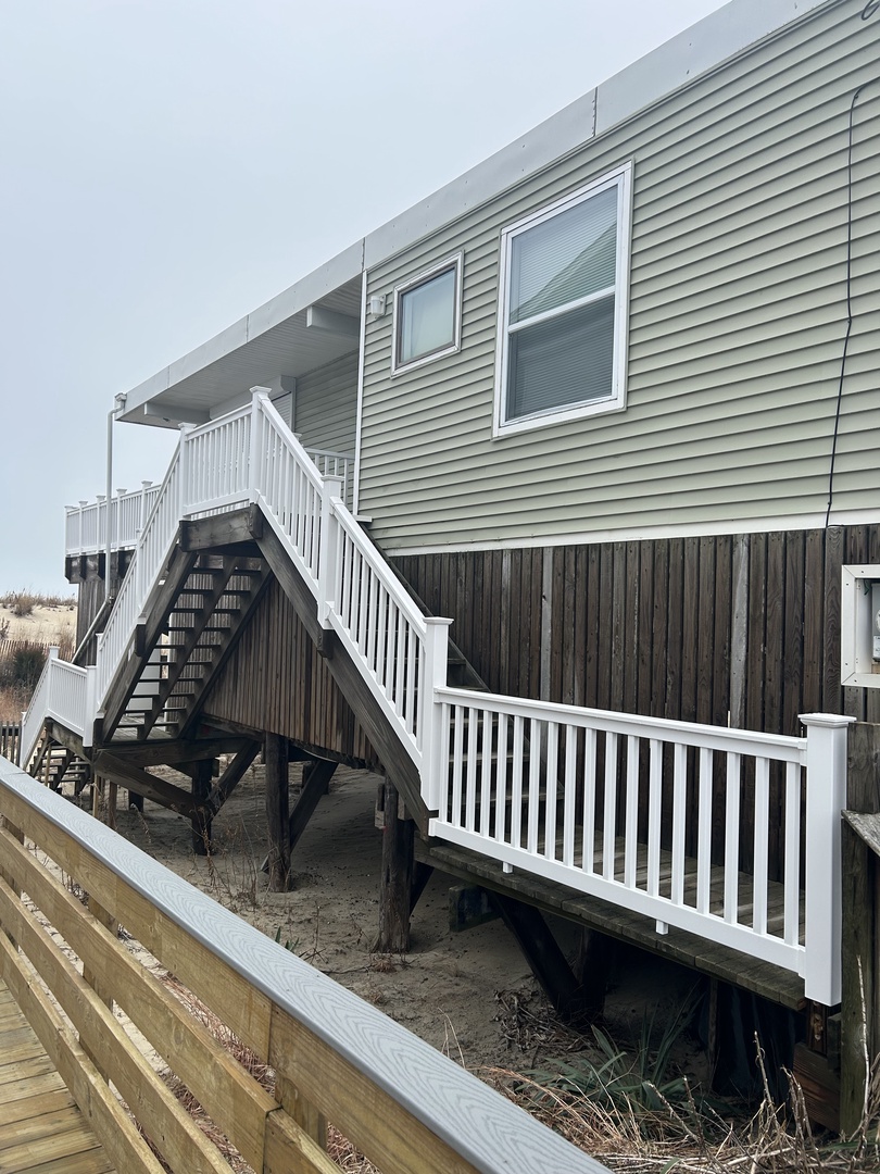 Modern vacation rental with distinctive architectural design featuring white railings and natural wood siding.