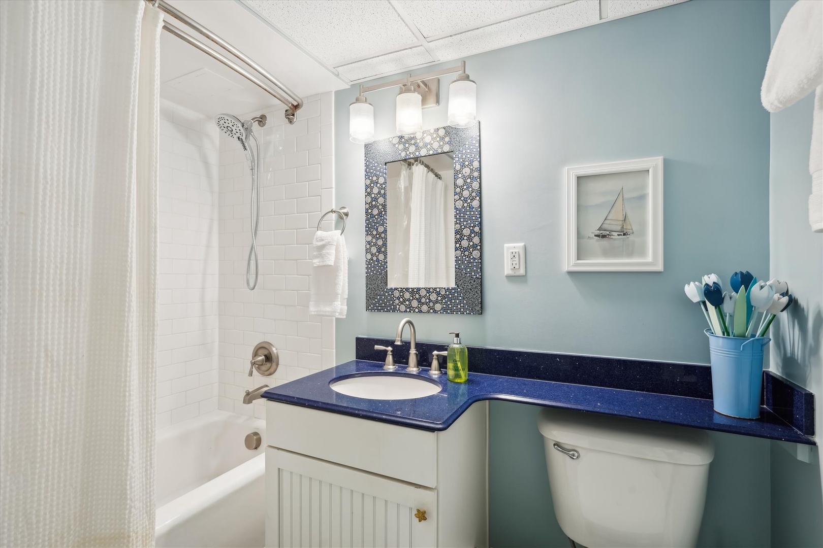 Refresh in your private coastal-inspired bathroom with soothing blue walls, sparkling blue countertops, and a tub-shower combo perfect for unwinding.