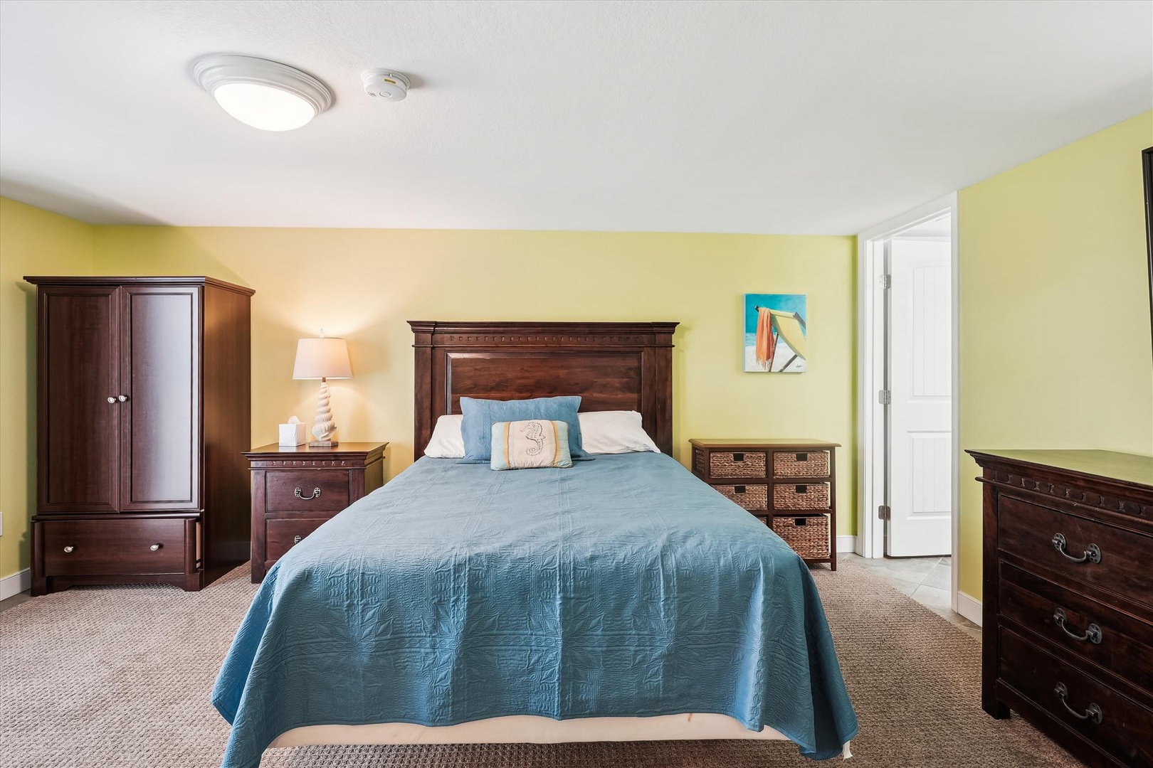 Settle into your serene bedroom, complete with a plush queen bed, rich wood furnishings, and calming coastal colors that invite restful nights and peaceful mornings.