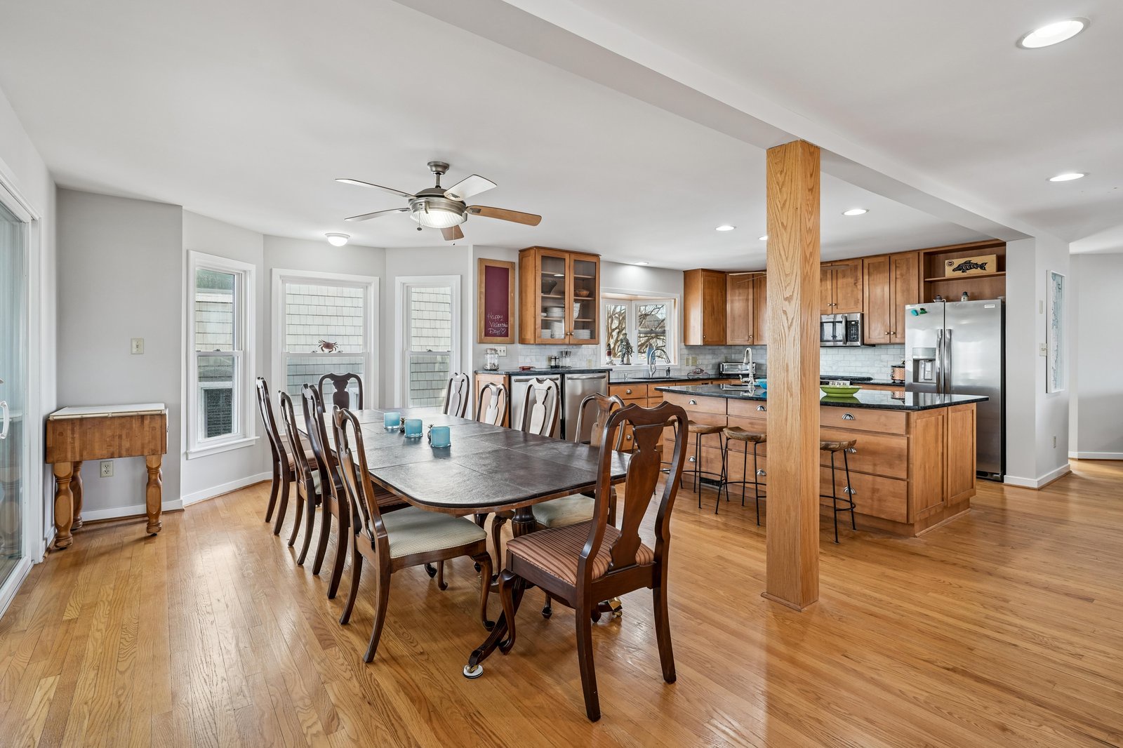 Step into your open-concept dining and kitchen area, where warm wood tones and bright natural light create an inviting space for memorable meals together.