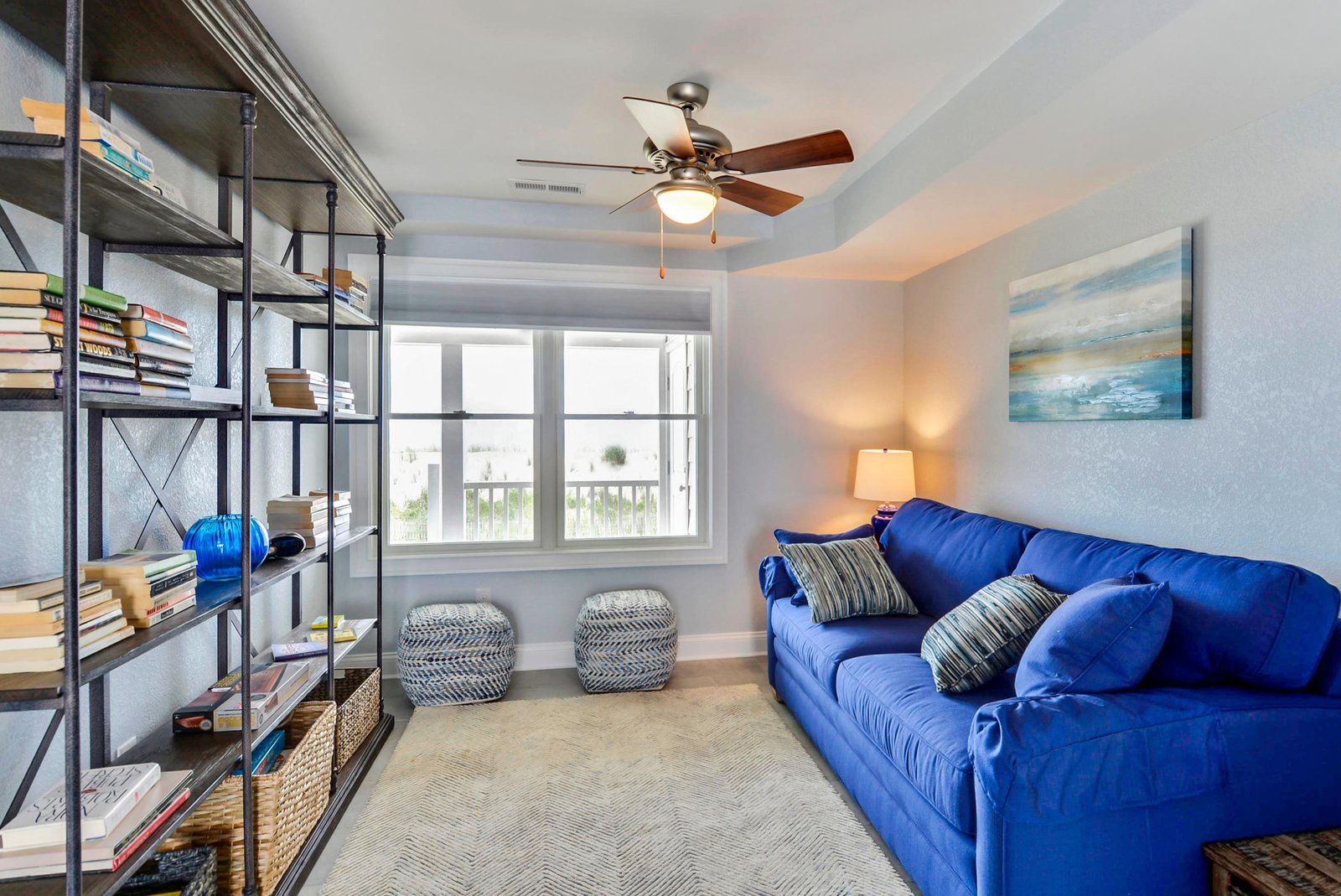 Sink into the plush blue sofa and unwind in your own cozy reading nook, where soft light and gentle ceiling fan breezes set the perfect tone for relaxation.