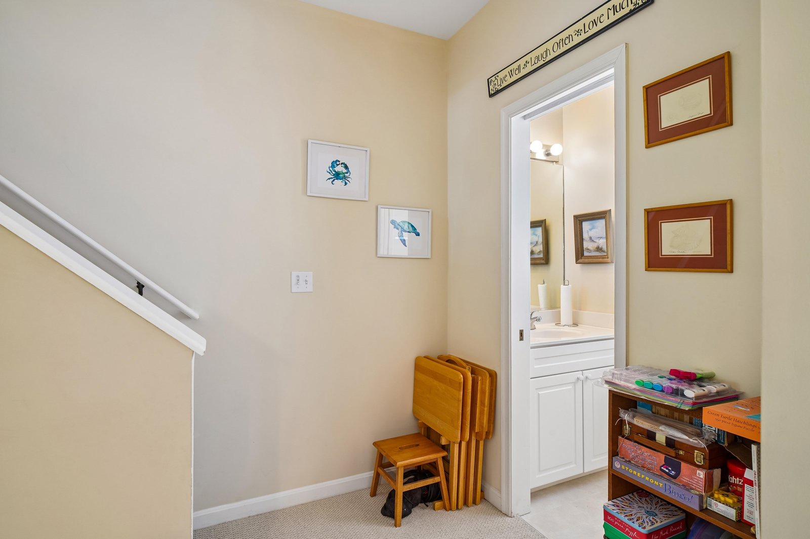 This bright hallway invites you into your beach-themed retreat, with coastal artwork welcoming you and a well-appointed bathroom within easy reach.