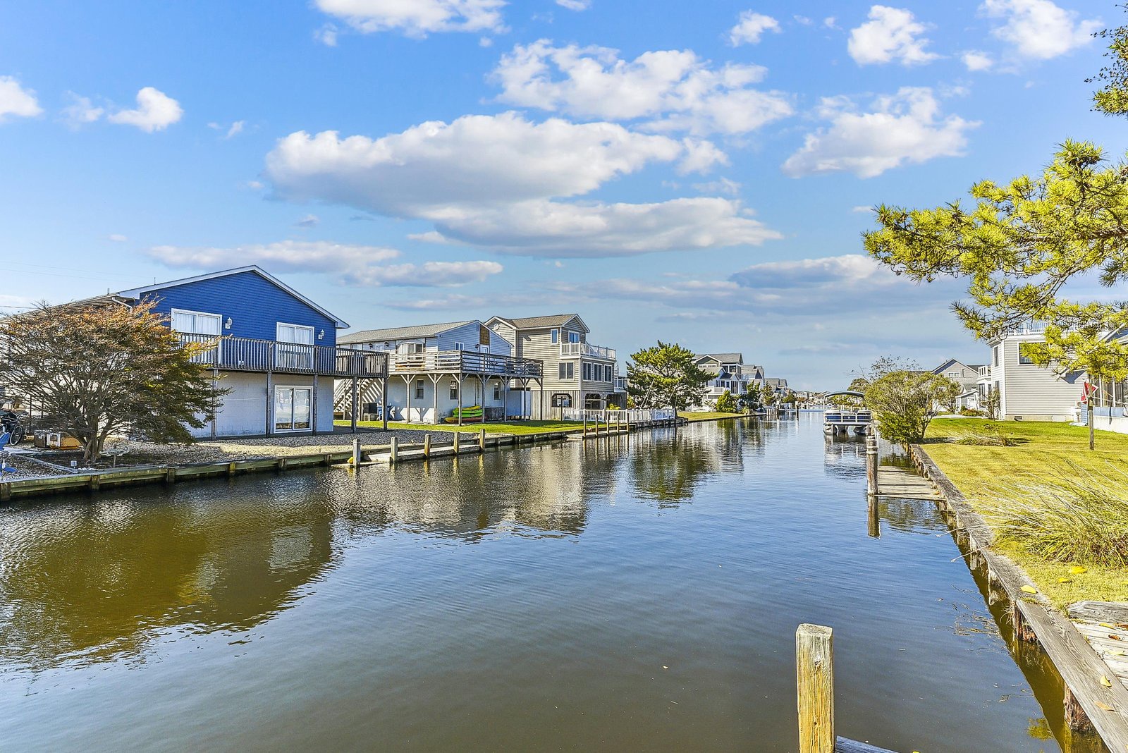 Waterfront community with private docks along a tranquil canal under blue skies, providing direct access to the water for boating and relaxation.
