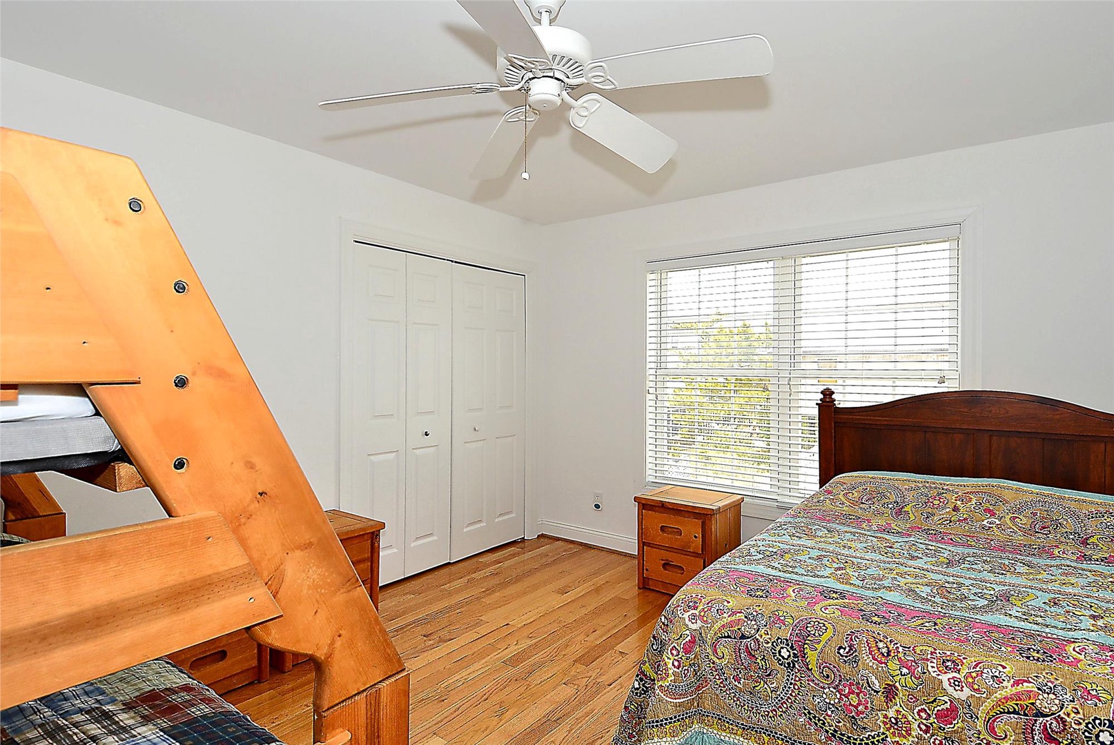 This cozy bedroom comfortably sleeps your family or group with a queen bed and built-in bunk bed. Natural light filters through window blinds, and a ceiling fan keeps everyone comfortable throughout the night.