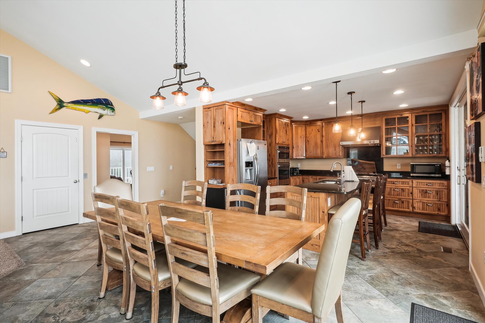 Picture yourself gathering around this spacious dining table, where warm wooden finishes and abundant natural light create the perfect setting for your meals together.