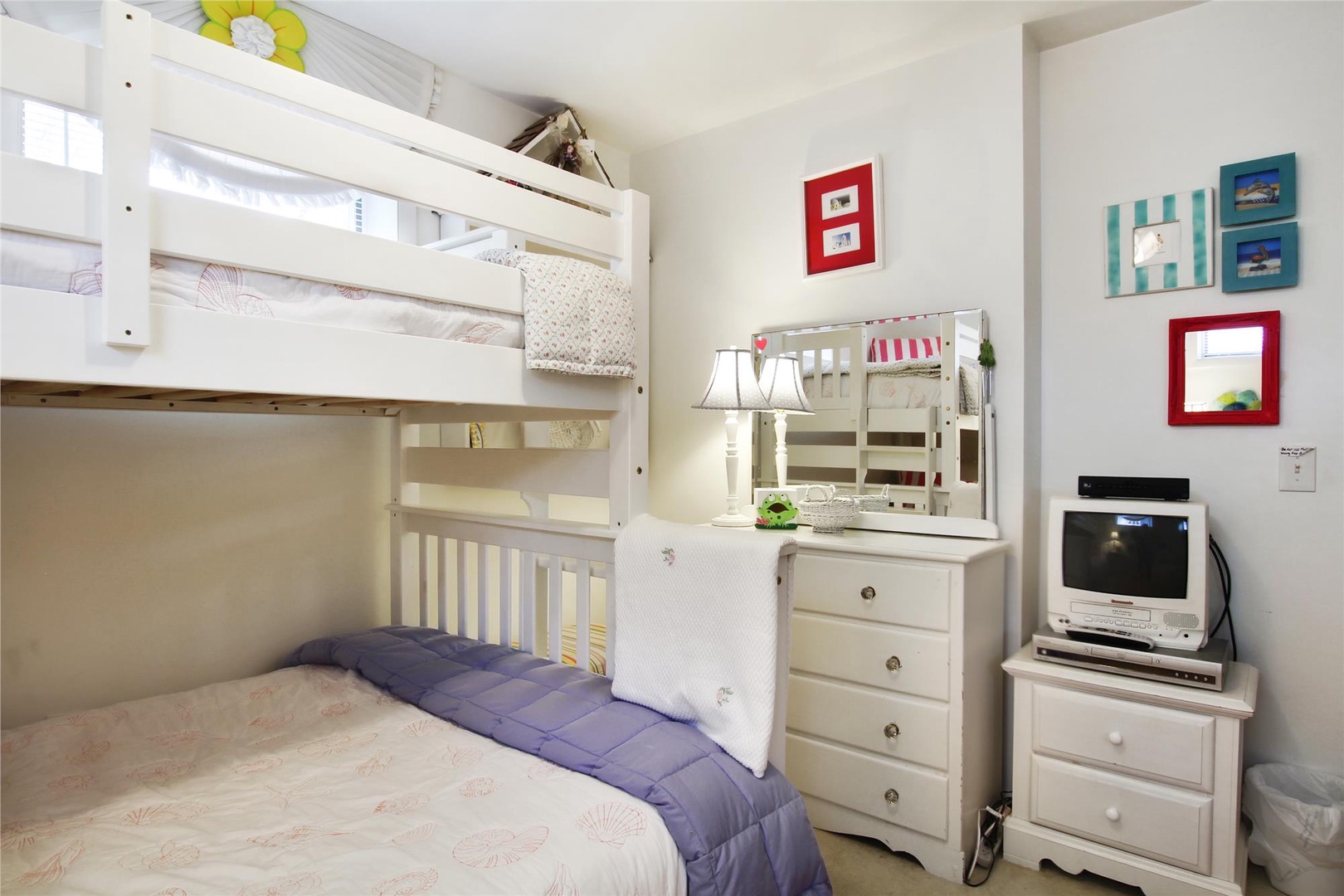 This charming bedroom offers cozy bunk bed accommodations and thoughtful touches like a dresser, mirror, and entertainment center—perfect for families or friends traveling together.