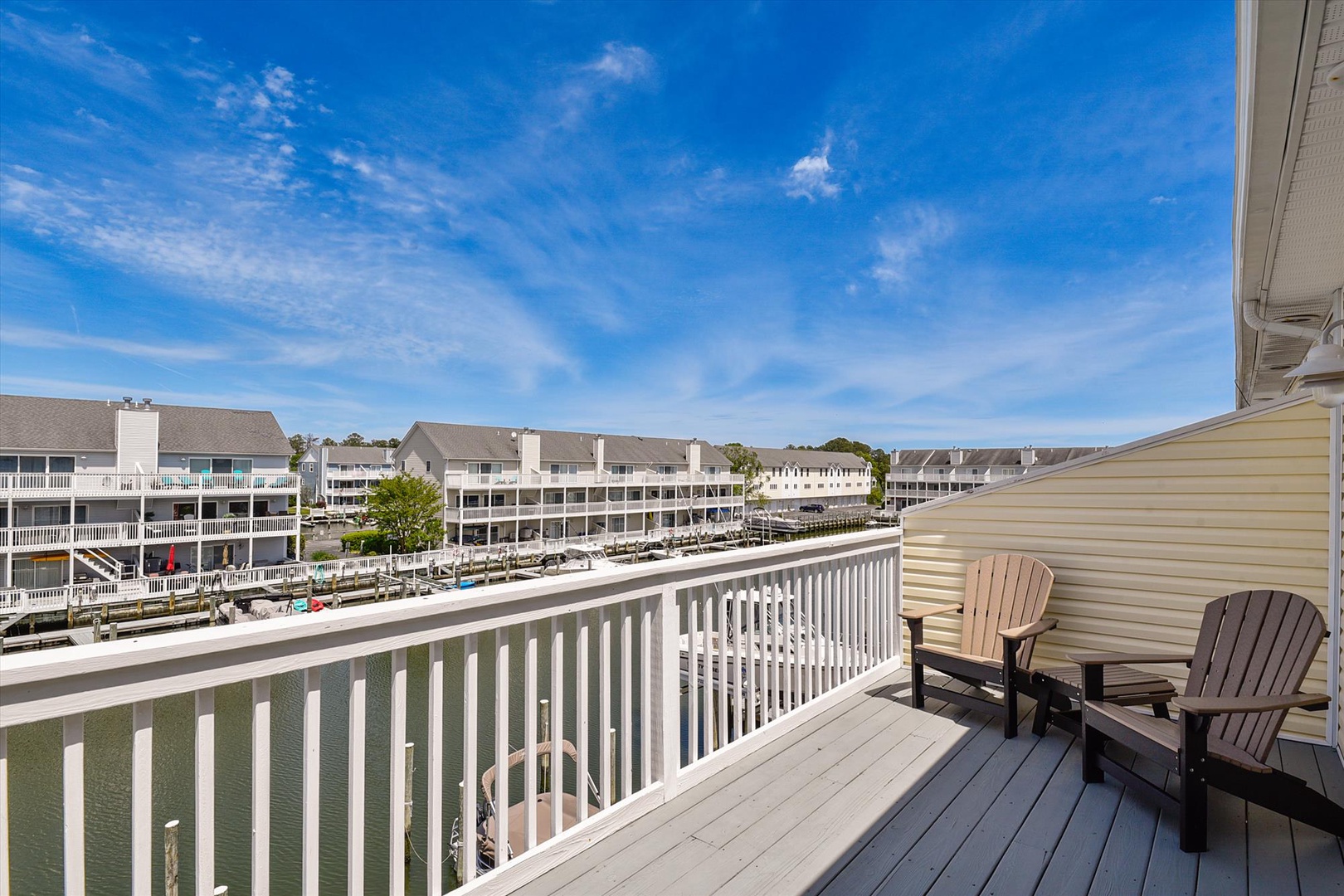 Relax in your Adirondack chairs on the private balcony overlooking serene canal views, where warm breezes and open skies create the perfect coastal escape for morning coffee or sunset moments.