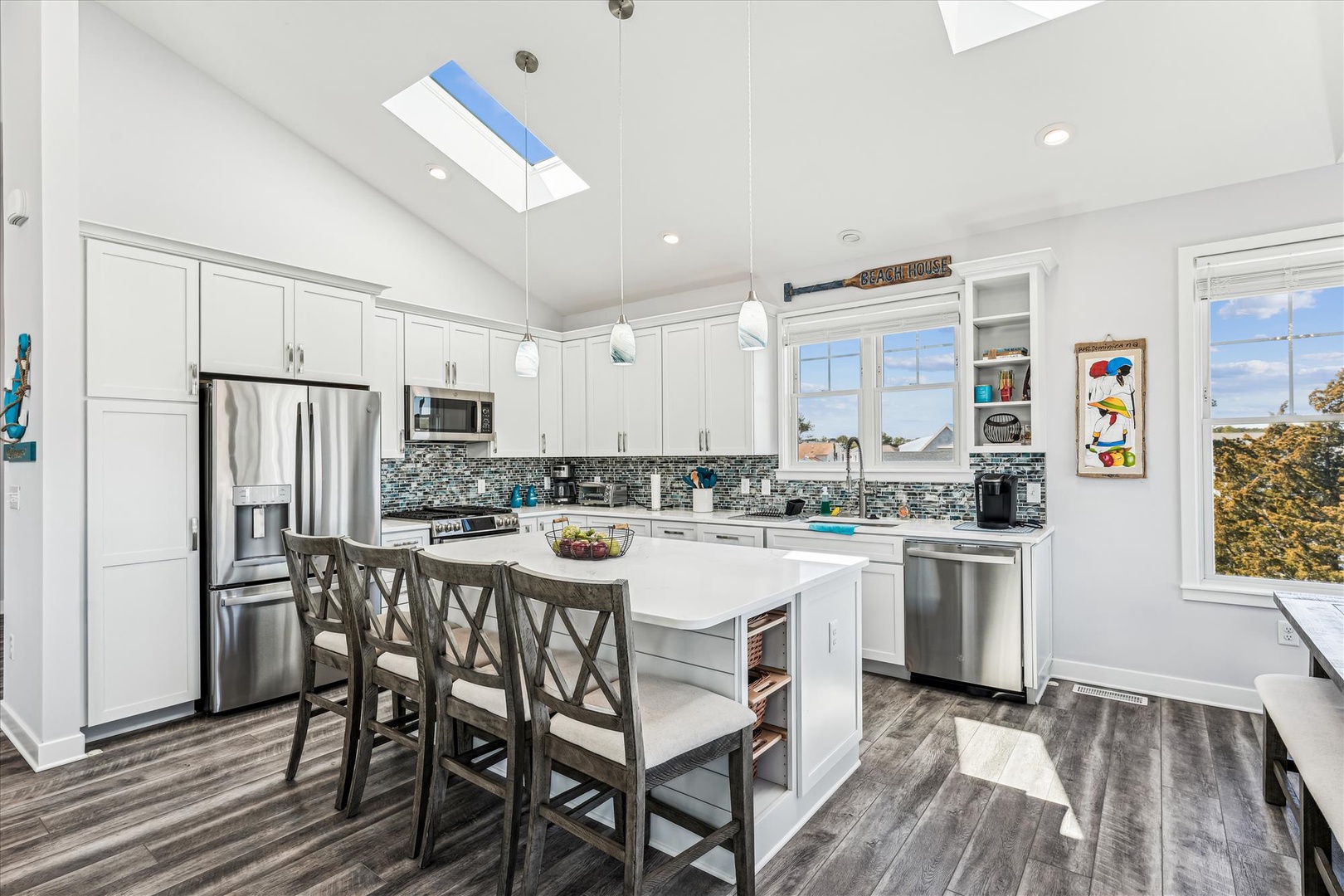 Your fully equipped kitchen awaits with modern appliances, spacious island seating, and skylights that fill the space with natural light.