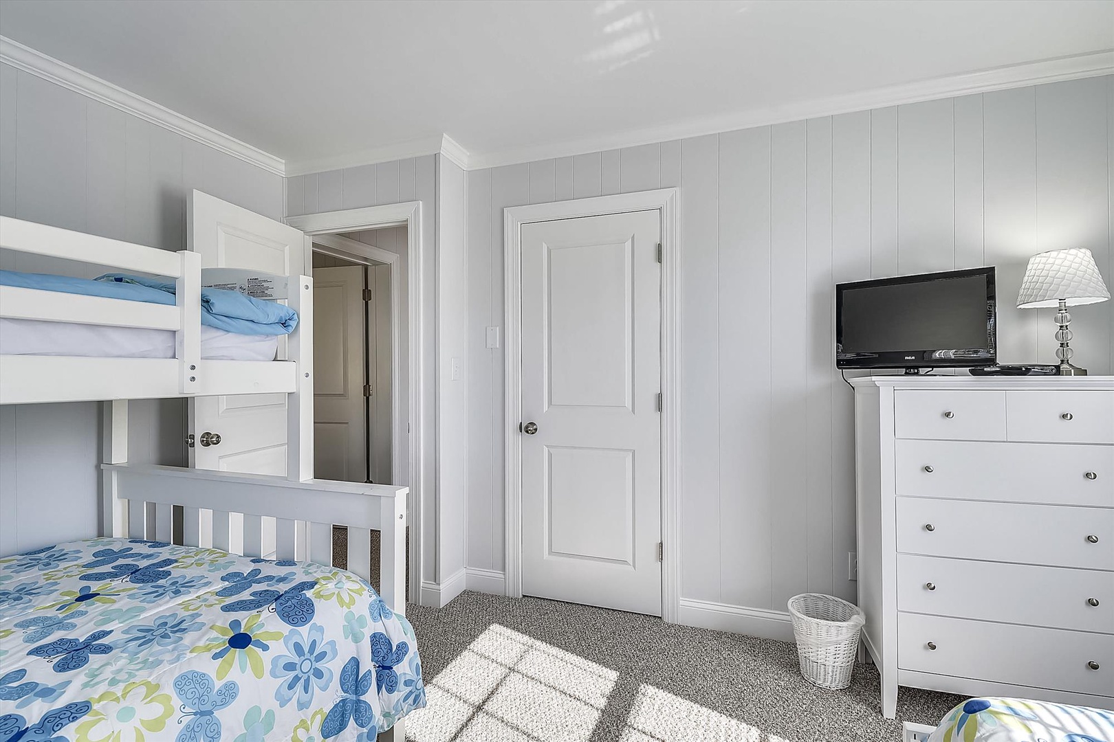 Bright bedroom with bunk beds and cozy furnishings—perfect for kids or extra guests. Enjoy entertainment with the flat-screen TV and unwind in your coastal-inspired space.