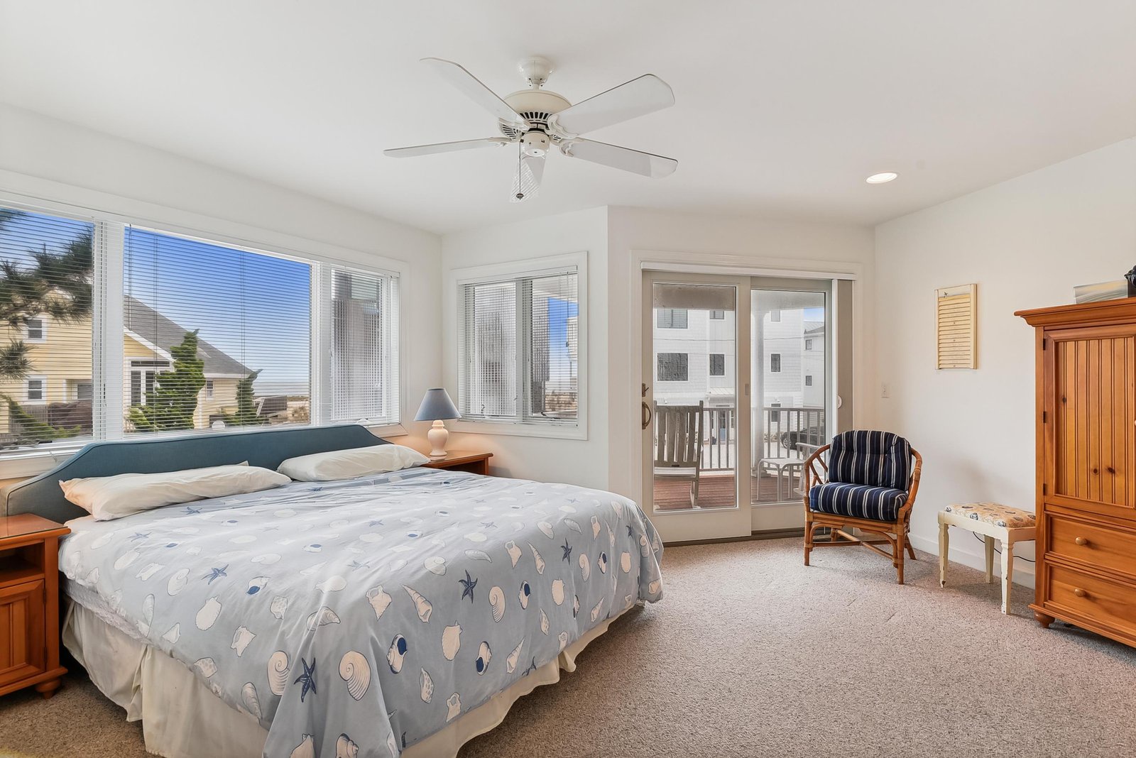 Relax in your bright bedroom with views of the neighborhood and private balcony access for morning ocean breezes.