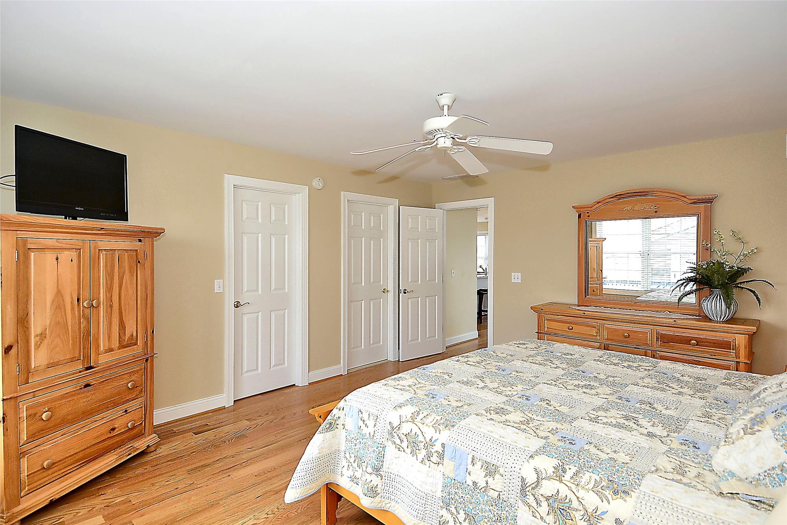 Relax in your spacious bedroom with warm wood tones, a ceiling fan to keep you cool, and a flat-screen TV for your favorite shows and movies.