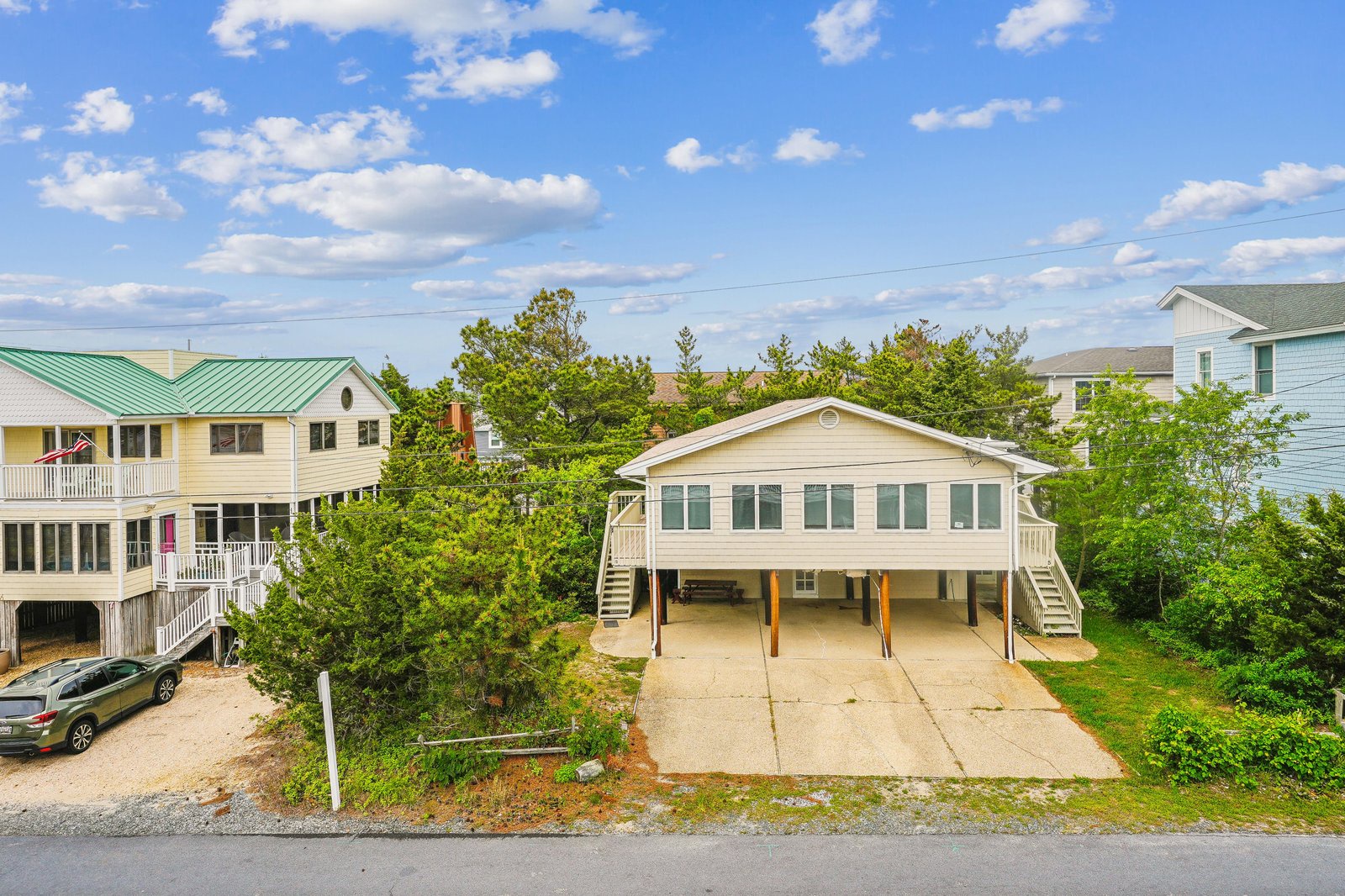 Charming elevated beach home nestled in a quiet coastal neighborhood, featuring convenient ground-level parking and easy access to nearby shores.