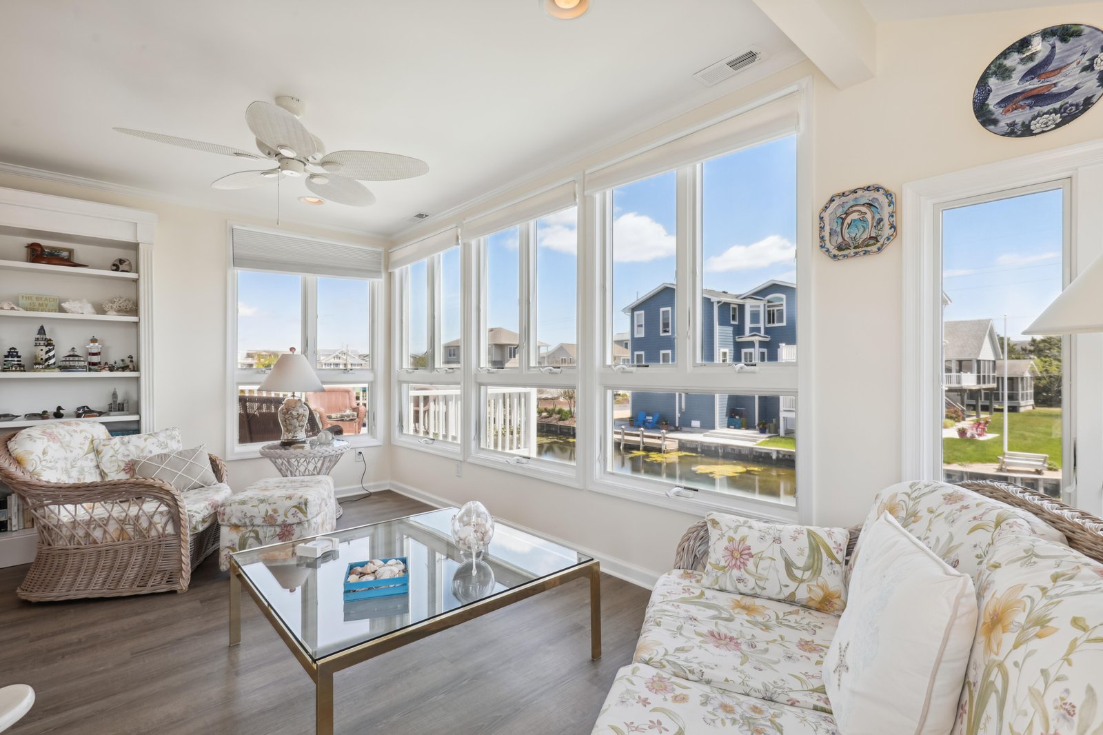 Settle into this sunlit living space with sweeping water views of the canal and nearby homes. Large windows invite you to unwind, while coastal-inspired furnishings and a gentle ceiling fan create a relaxing retreat perfect for your vacation.