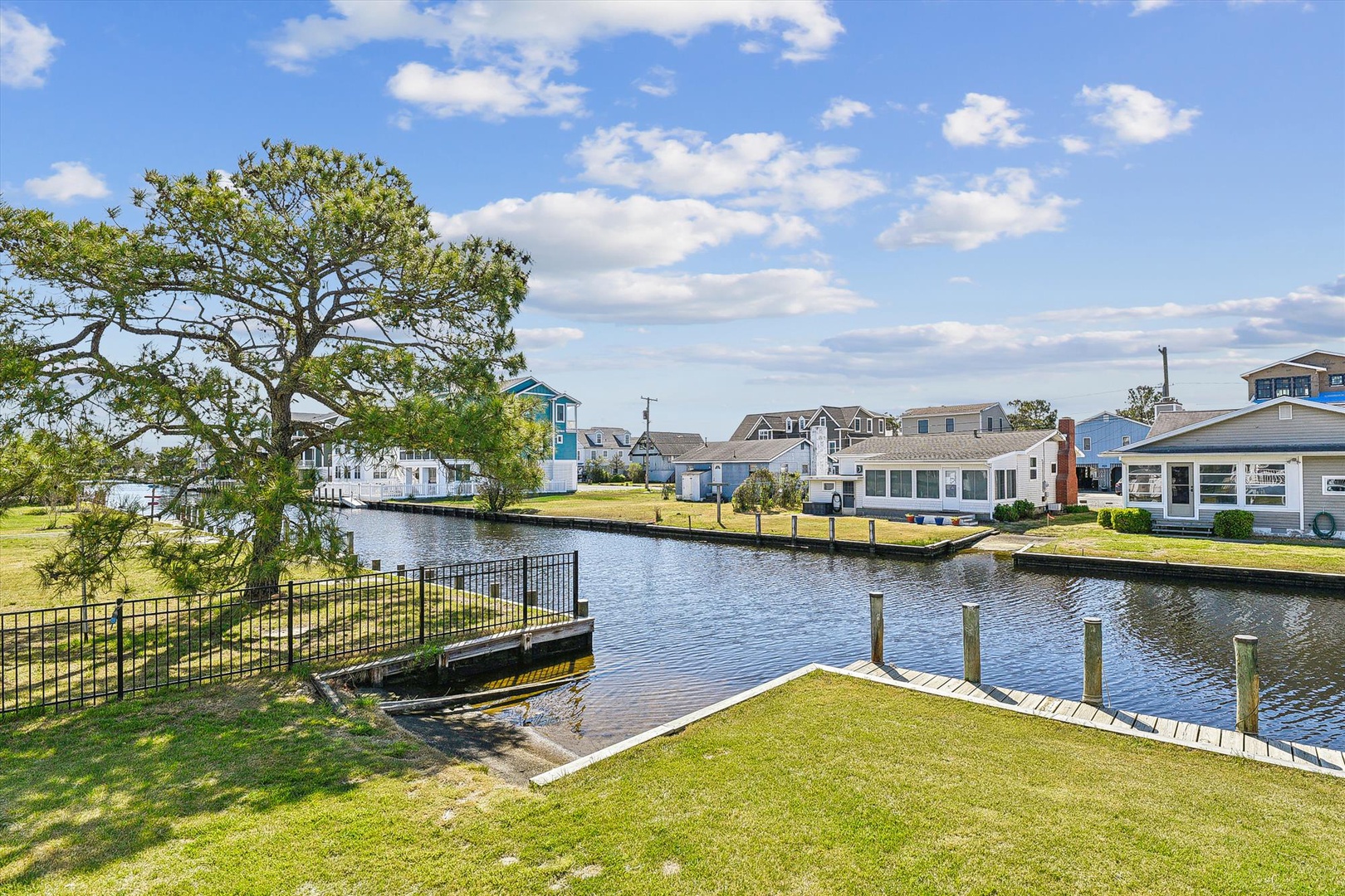 A tranquil waterfront neighborhood with canal access, nearby homes, and a scenic tree-lined landscape—part of the property's peaceful surroundings.