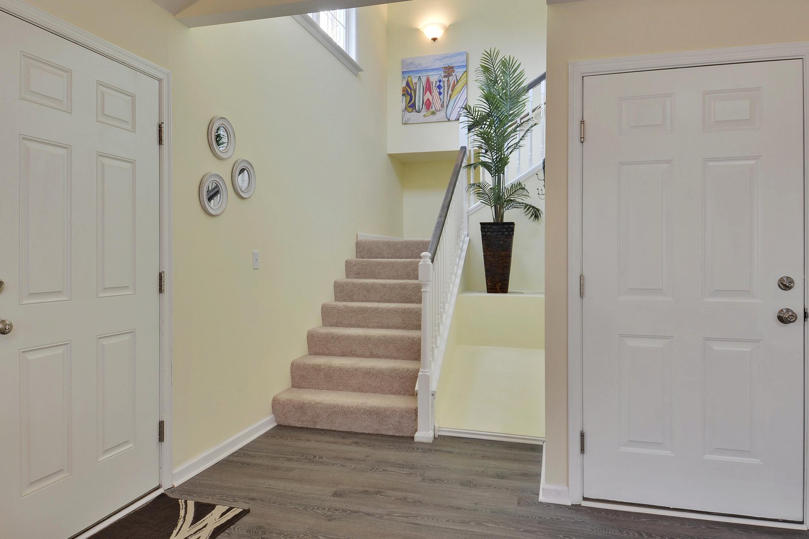Step inside to a bright, airy entryway where natural light spills down the staircase and fresh coastal style welcomes you home.