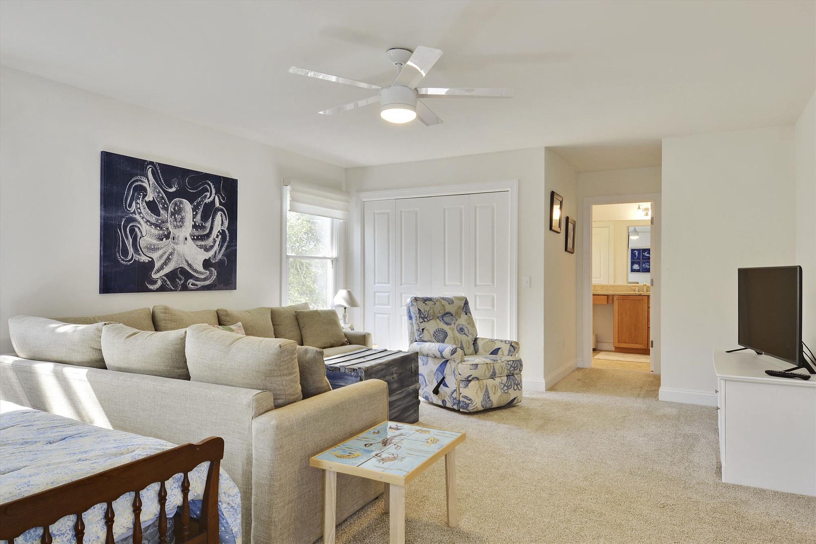 Unwind in your spacious living room featuring plush seating, coastal artwork, and entertainment center for relaxing evenings.