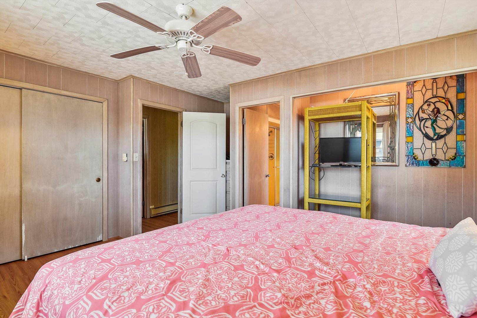 Drift off in your cozy bedroom with cheerful coastal decor, a ceiling fan to keep you cool, and your own TV for late-night relaxation.