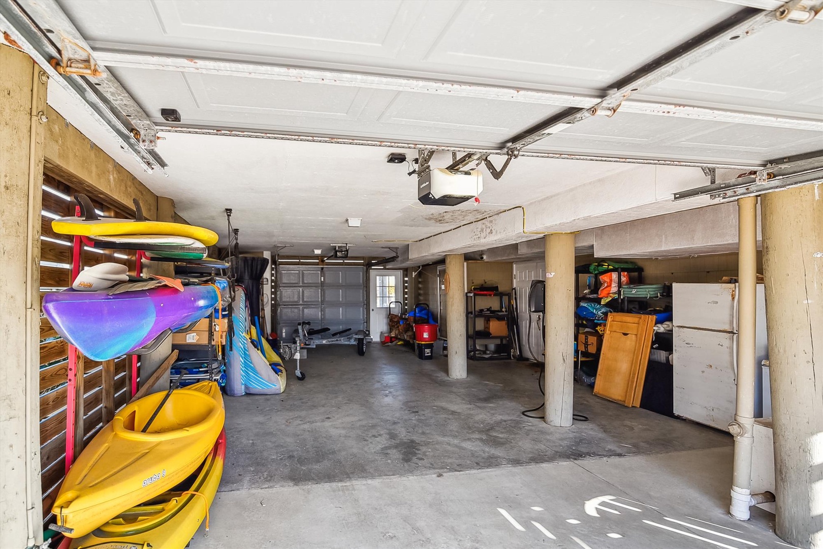 Spacious garage with kayak storage, shelving, and dedicated parking—ready for all your beach adventures and equipment.