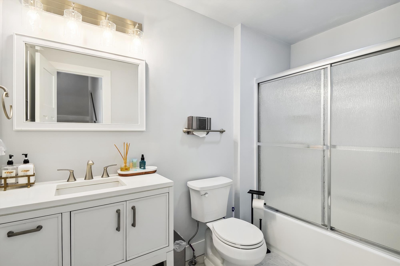 Freshen up in your private bathroom featuring a spacious vanity, rainfall shower, and bright lighting—everything you need for a comfortable stay.