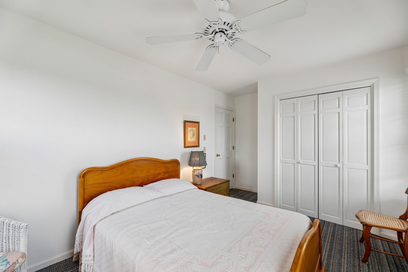 Rest easy in your bright, airy bedroom featuring a cozy bed, ceiling fan, and generous closet space for all your belongings.