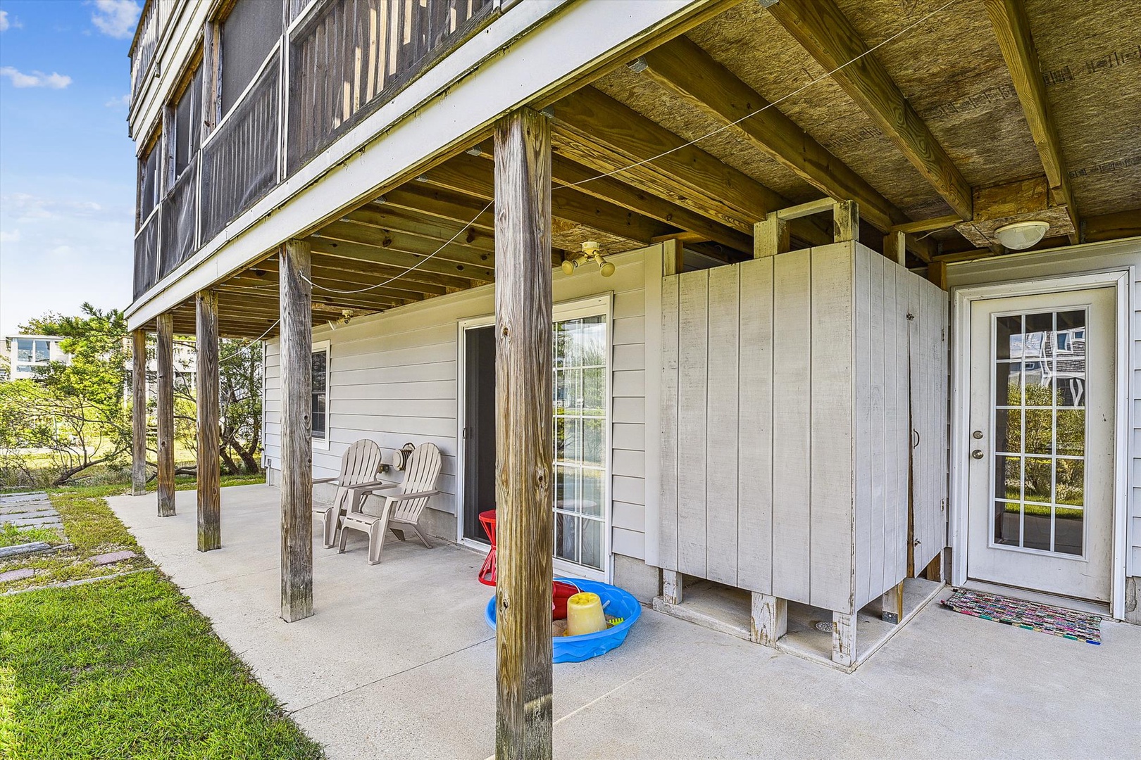 A spacious covered patio provides a welcoming entry with shaded seating and a colorful play area perfect for young guests to enjoy while you settle in.