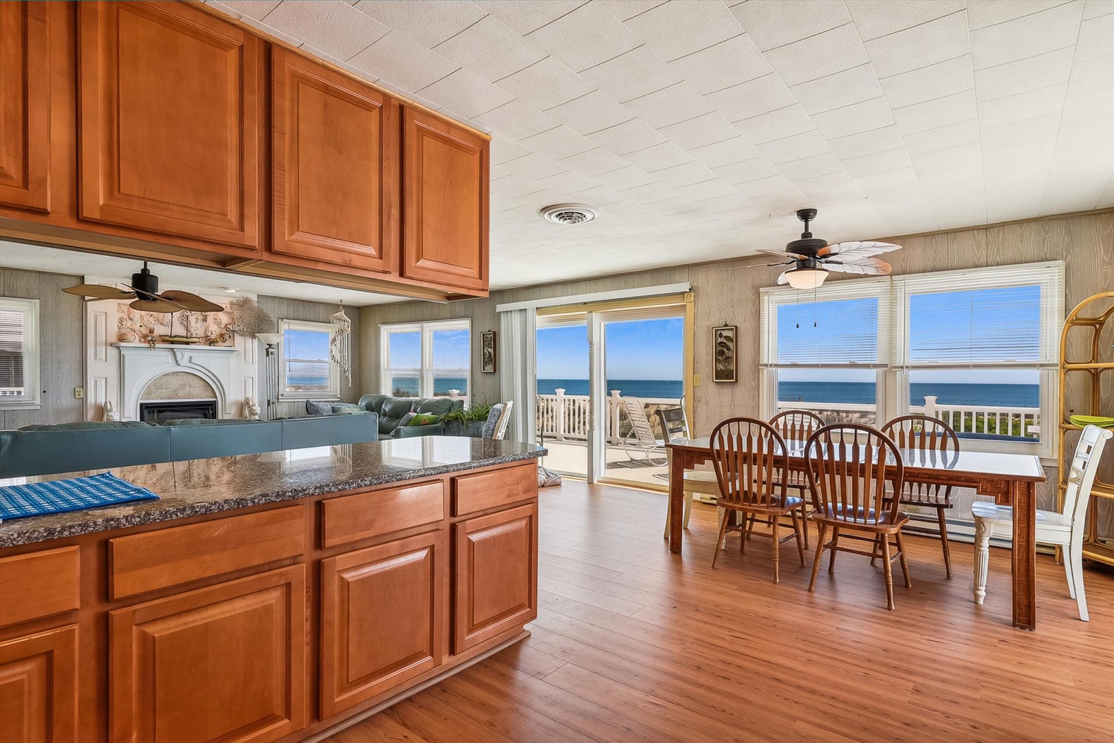 Open kitchen and dining space with stunning ocean views, perfect for preparing meals and gathering around the table as waves roll in just beyond your deck.