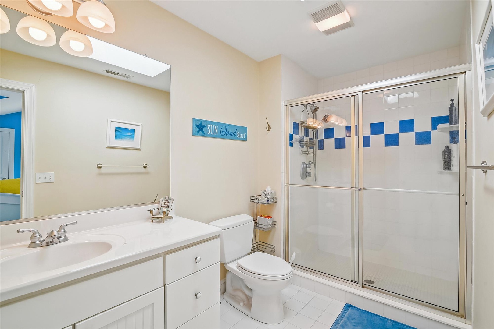 Your bright bathroom features cheerful blue accents, spacious shower, and coastal charm for refreshing mornings.