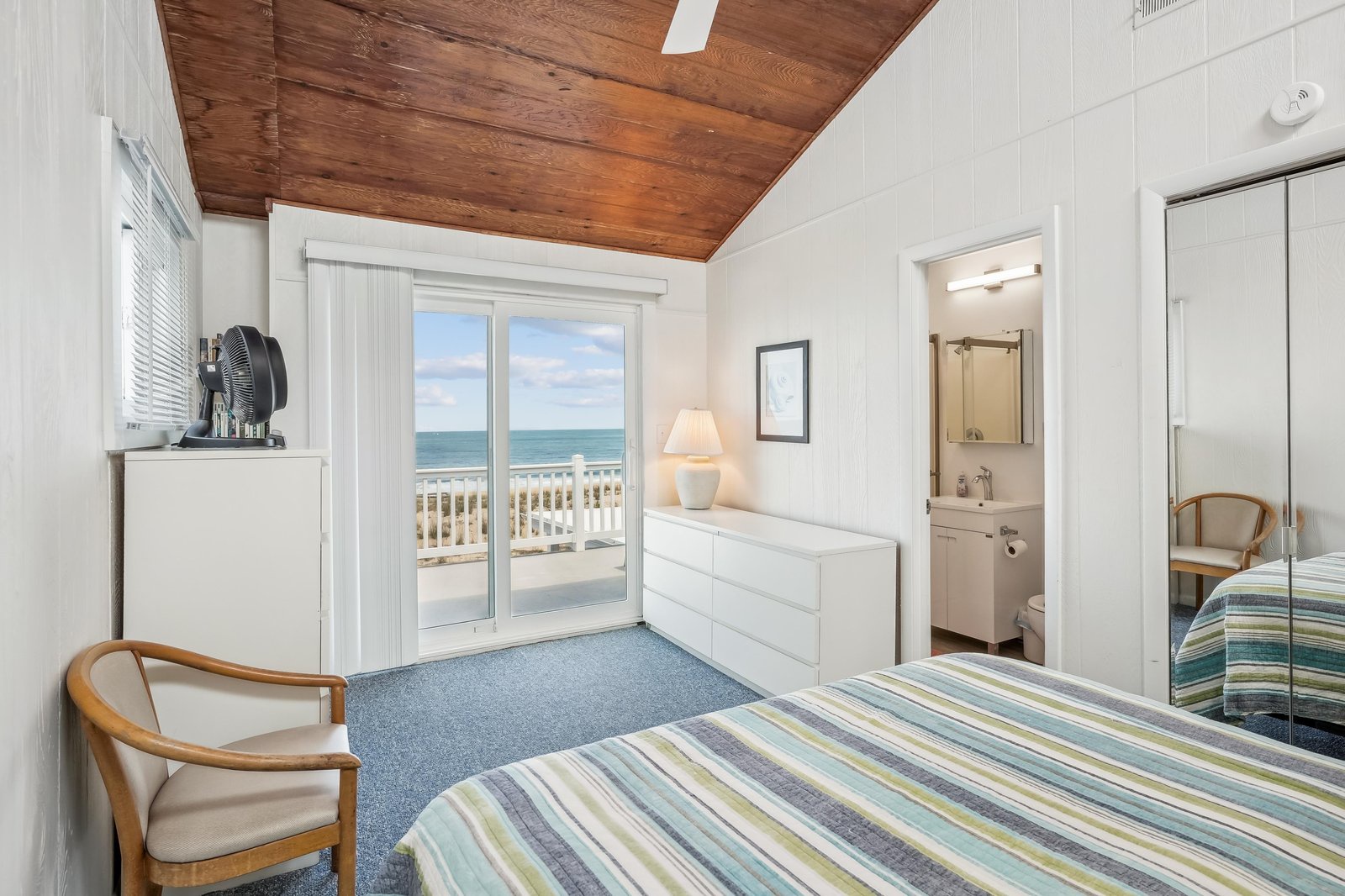 Step out onto your private balcony and let the ocean breeze welcome you. Inside, your bright bedroom features a warm wood ceiling, coastal décor, and an en-suite bathroom for complete comfort.