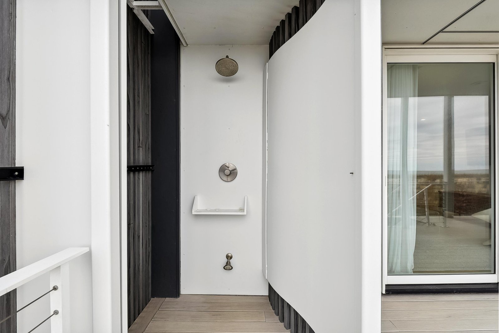 Modern outdoor shower area with sleek, minimalist design—perfect for rinsing off after a day of exploring or enjoying the nearby beach.