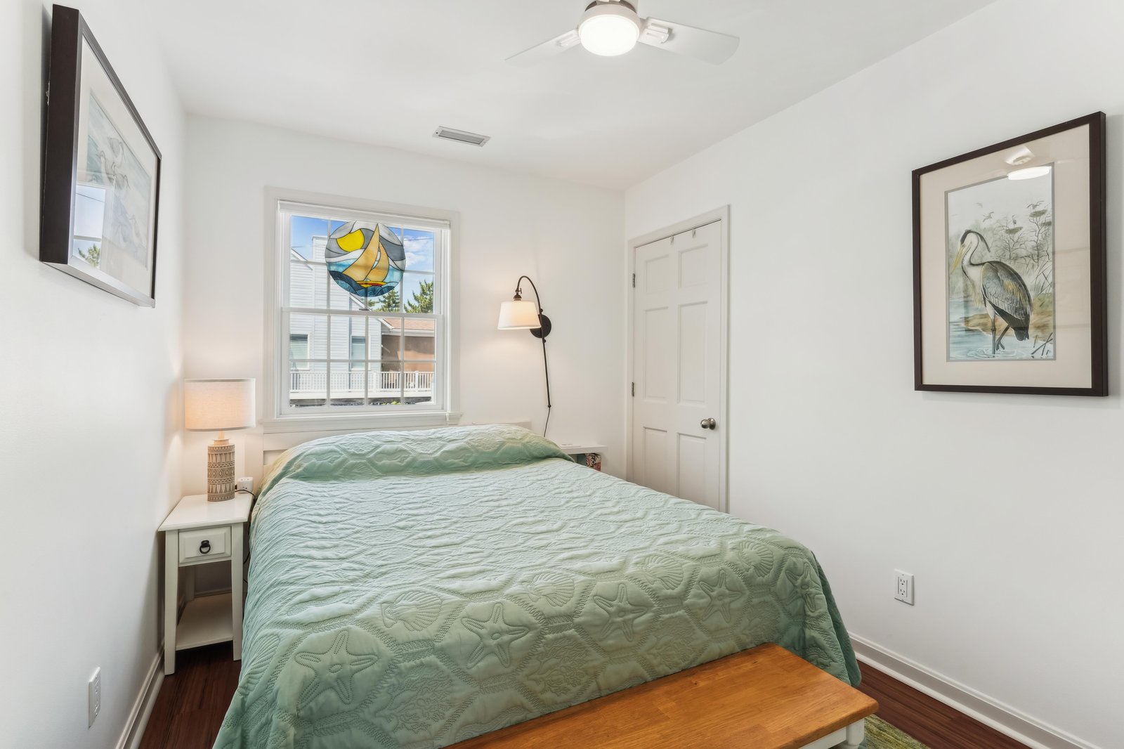Your bright, coastal-inspired bedroom welcomes restful nights with fresh linens, warm wood floors, and charming seaside artwork to set the mood for your getaway.