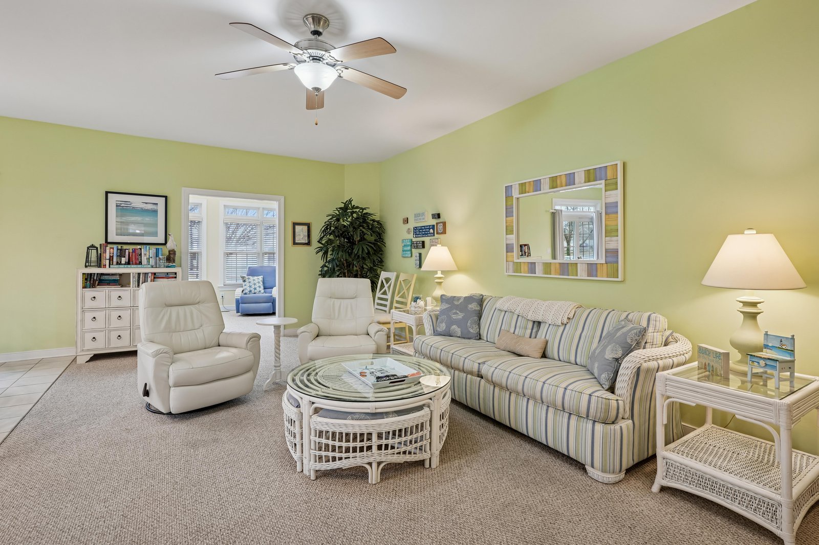 Sink into the plush seating, feel the breeze from the ceiling fan, and let the cheerful yellow walls lift your spirits as you unwind in this bright, welcoming living room.