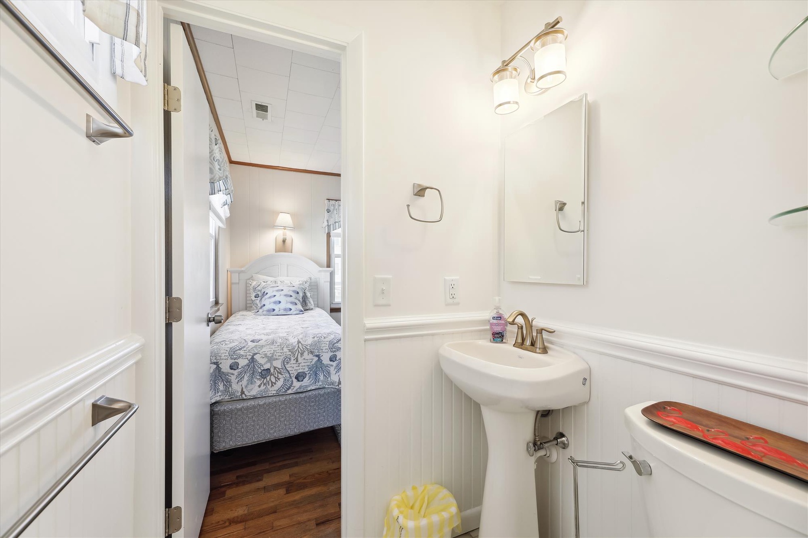 Your bright, private bathroom connects directly to a charming bedroom with coastal-inspired bedding, offering convenience and a relaxing retreat after a full day exploring.