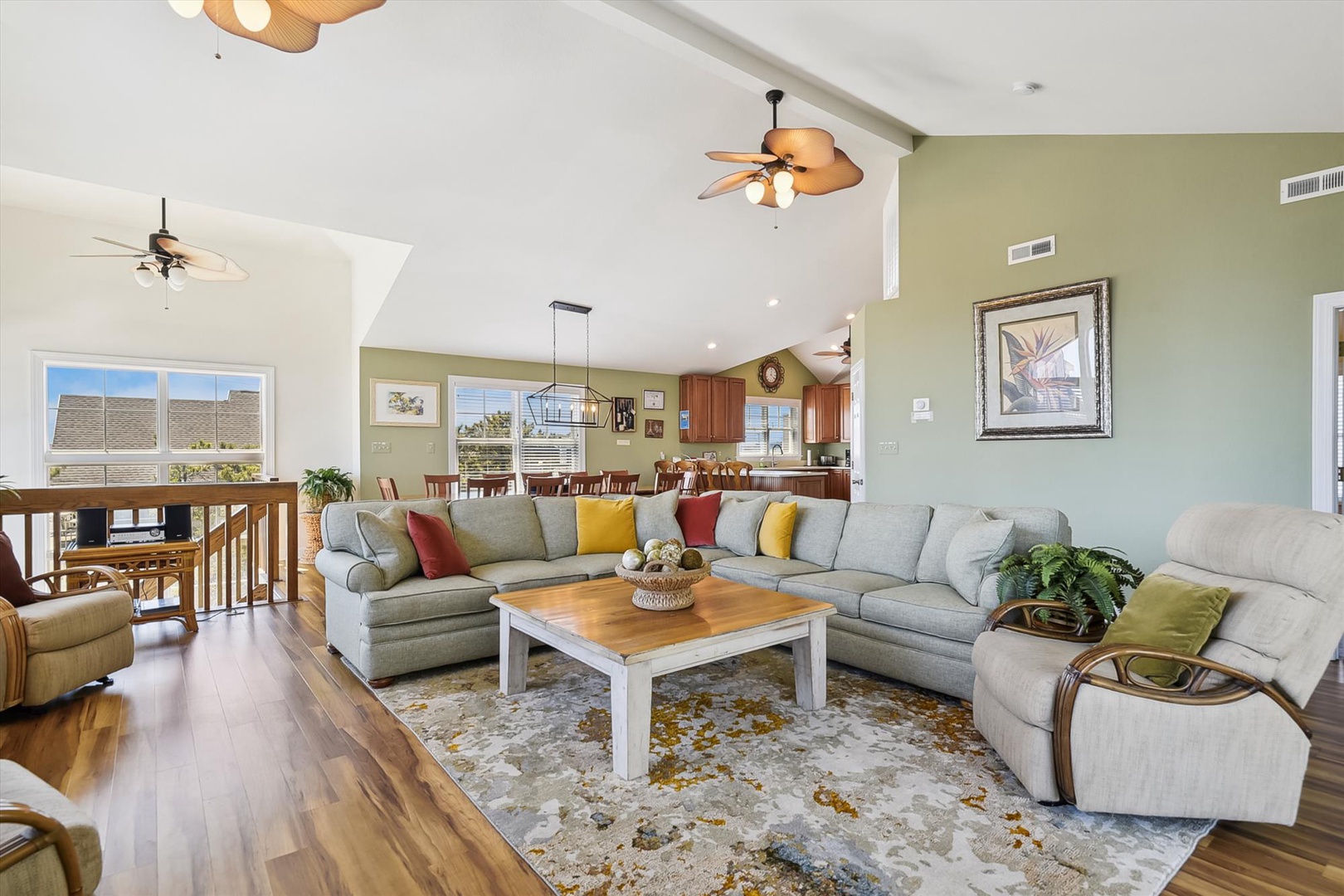 Sink into plush seating in your spacious living room, where vaulted ceilings, tropical breezes from ceiling fans, and warm wood floors create an inviting space to gather and unwind together.