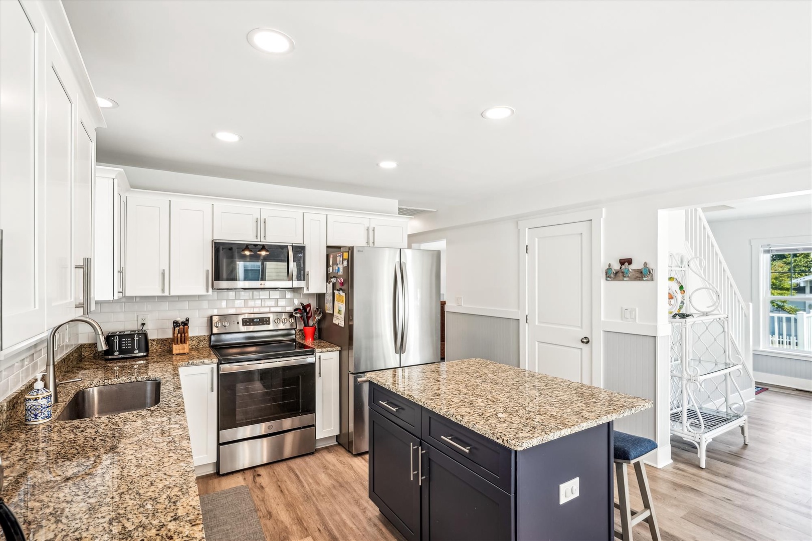 Prepare gourmet meals in your spacious kitchen featuring granite counters, stainless steel appliances, and a large island perfect for cooking together.