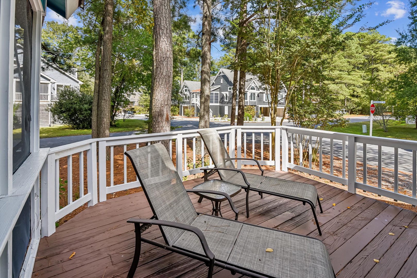 Relax on your private deck with comfortable lounge chairs, surrounded by peaceful tree-lined neighborhood views.