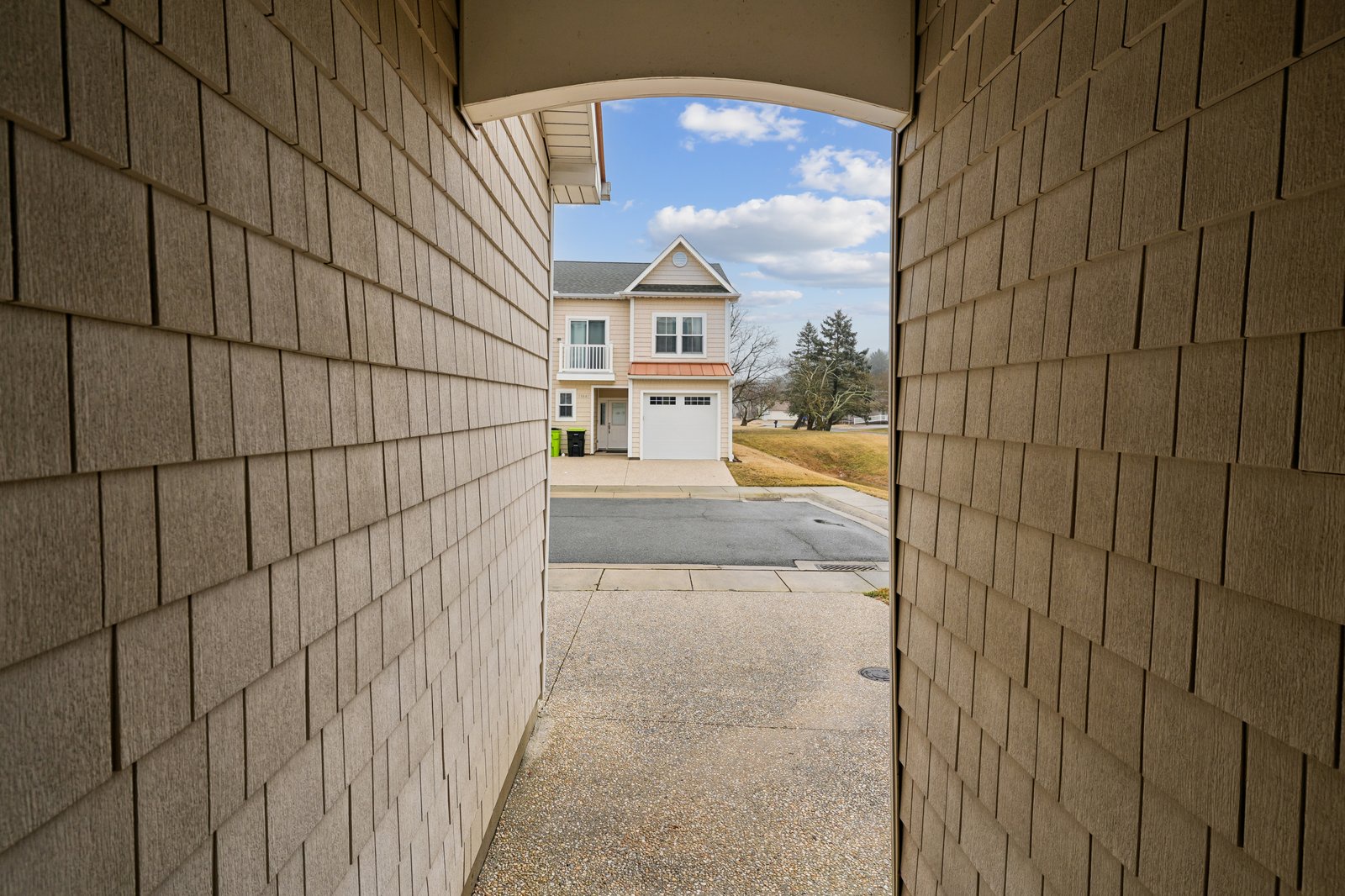 Charming residential community entrance showcasing well-maintained neighborhood homes with convenient driveway parking.