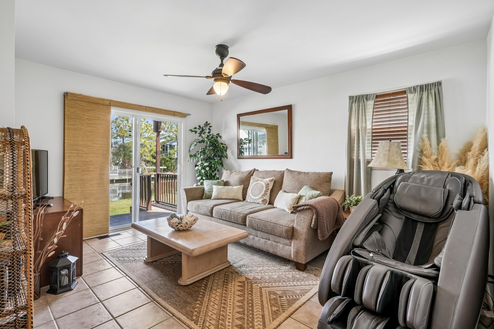 Unwind in your cozy living room with plush seating, modern massage chair, and serene garden views through sliding glass doors—your perfect retreat after a day of adventure.