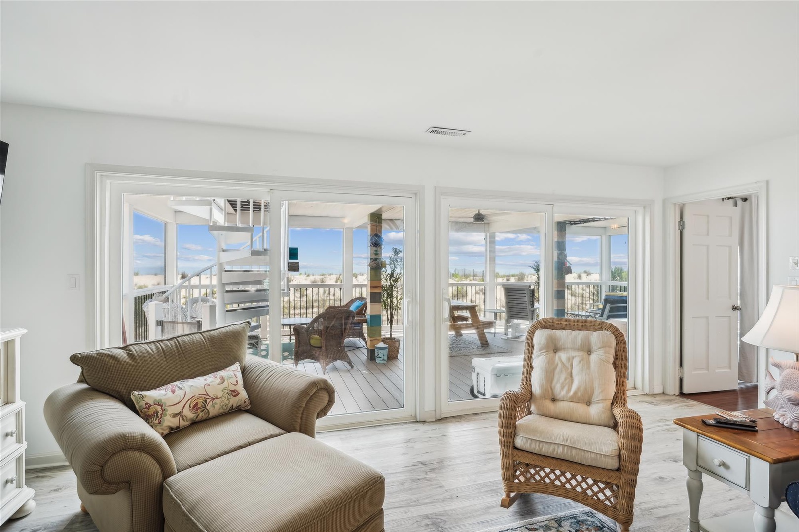 Relax in your comfortable living space with sweeping views through glass doors opening to a private deck overlooking the scenic coastal landscape.