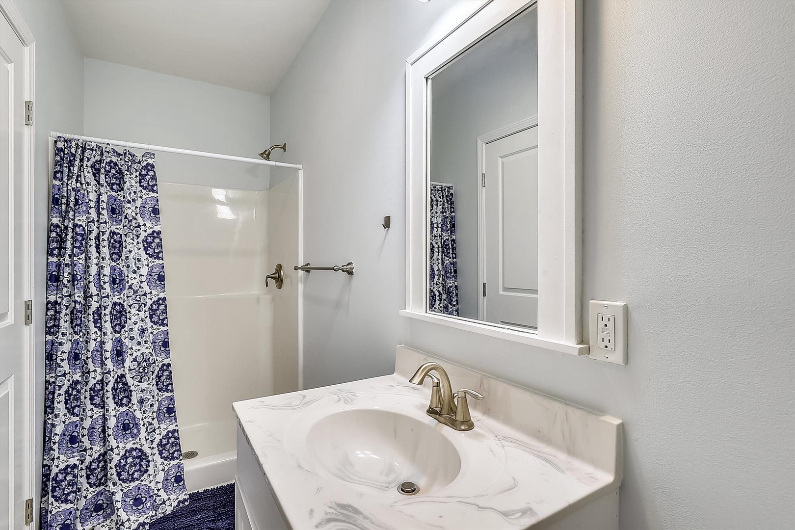 Freshen up in your sparkling bathroom with marble vanity, bright lighting, and a relaxing shower—everything you need for a comfortable stay.